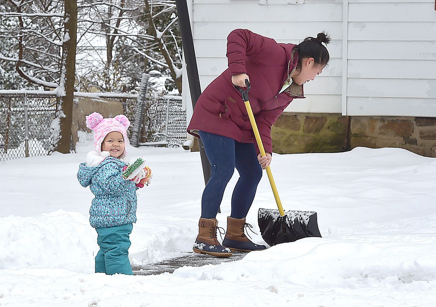  For two year-old Savannah Bohne the snow is fun, for mom- Victoria Bohne, not so muuch as she clears her walks in Springfield Thursday morning
