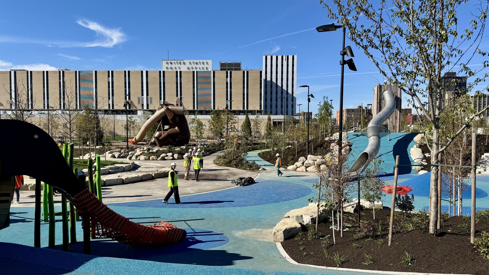 A playground features blue spongy ground, animal shaped slides including a bear, and another metal slide.