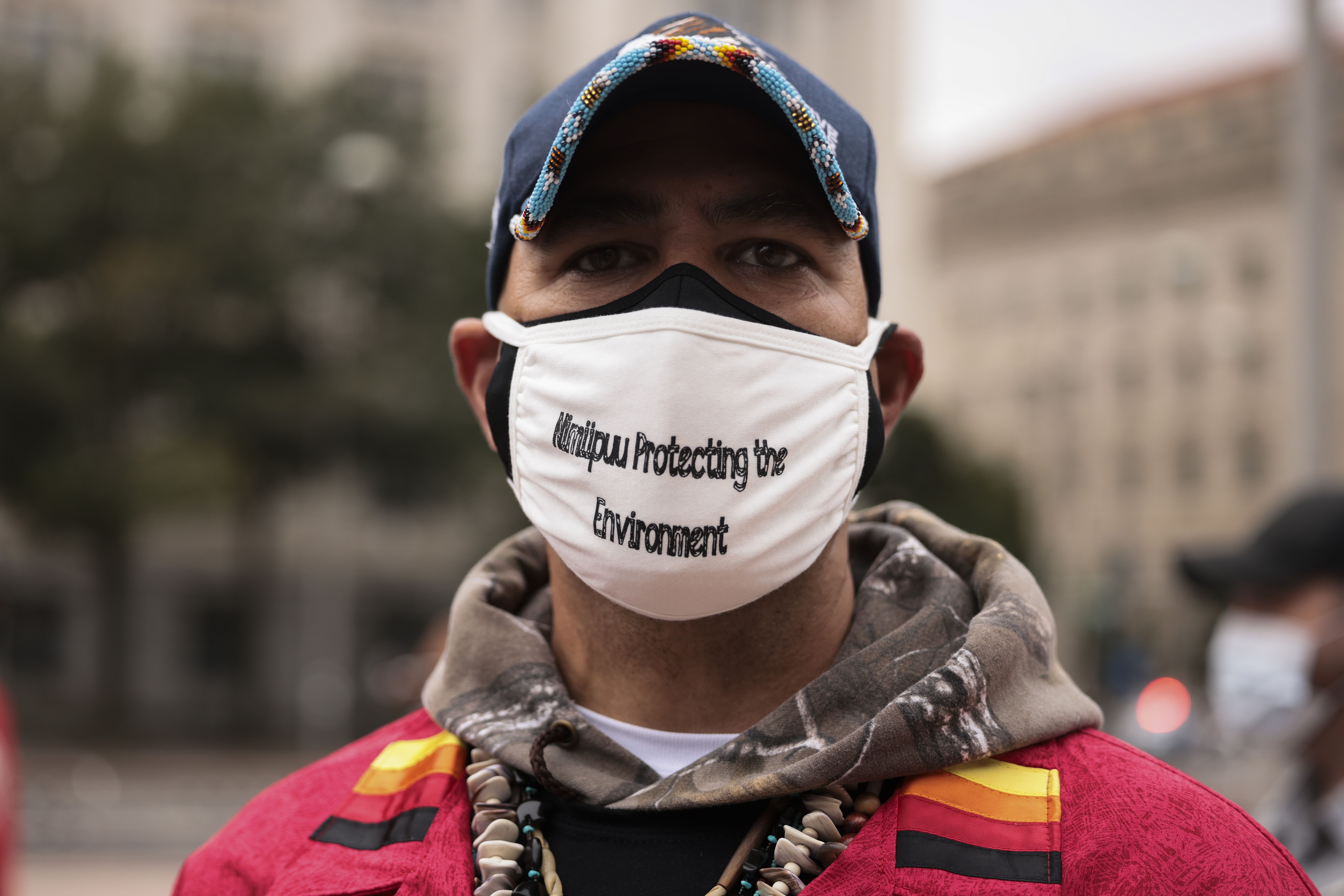 A man with a facemask advocating for environmental protection poses for a portrait 