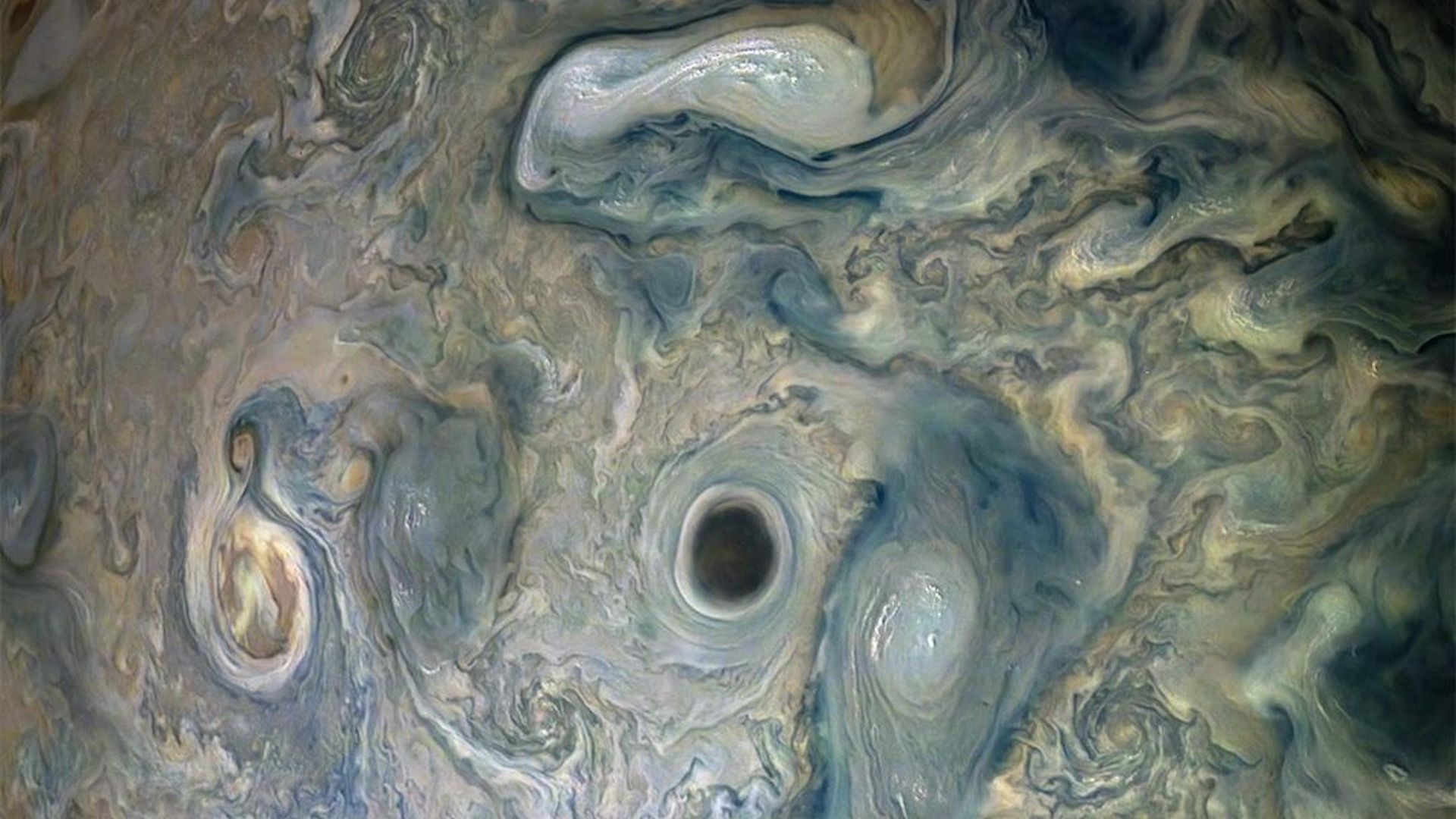 A dark vortex swirls on Jupiter.