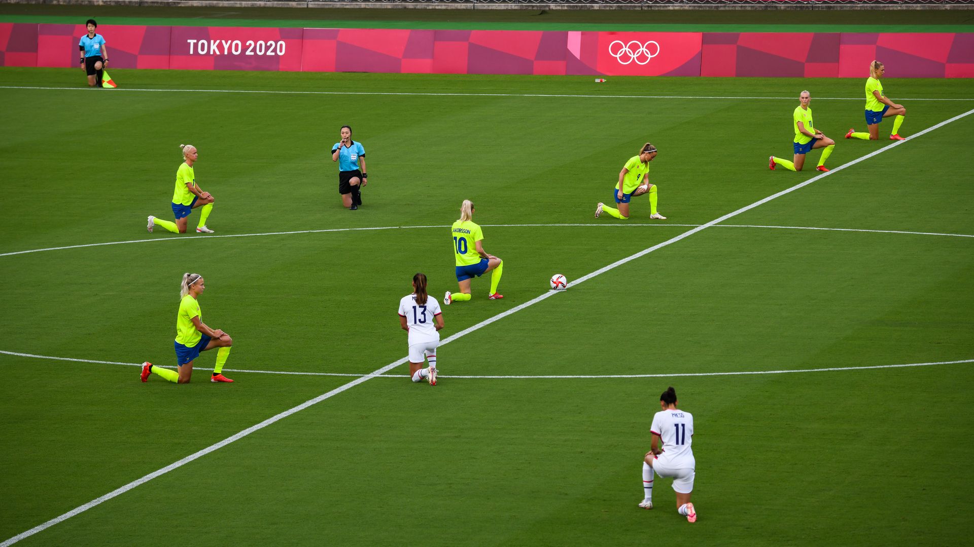 Picture of soccer female players taking a knee in the Olympics