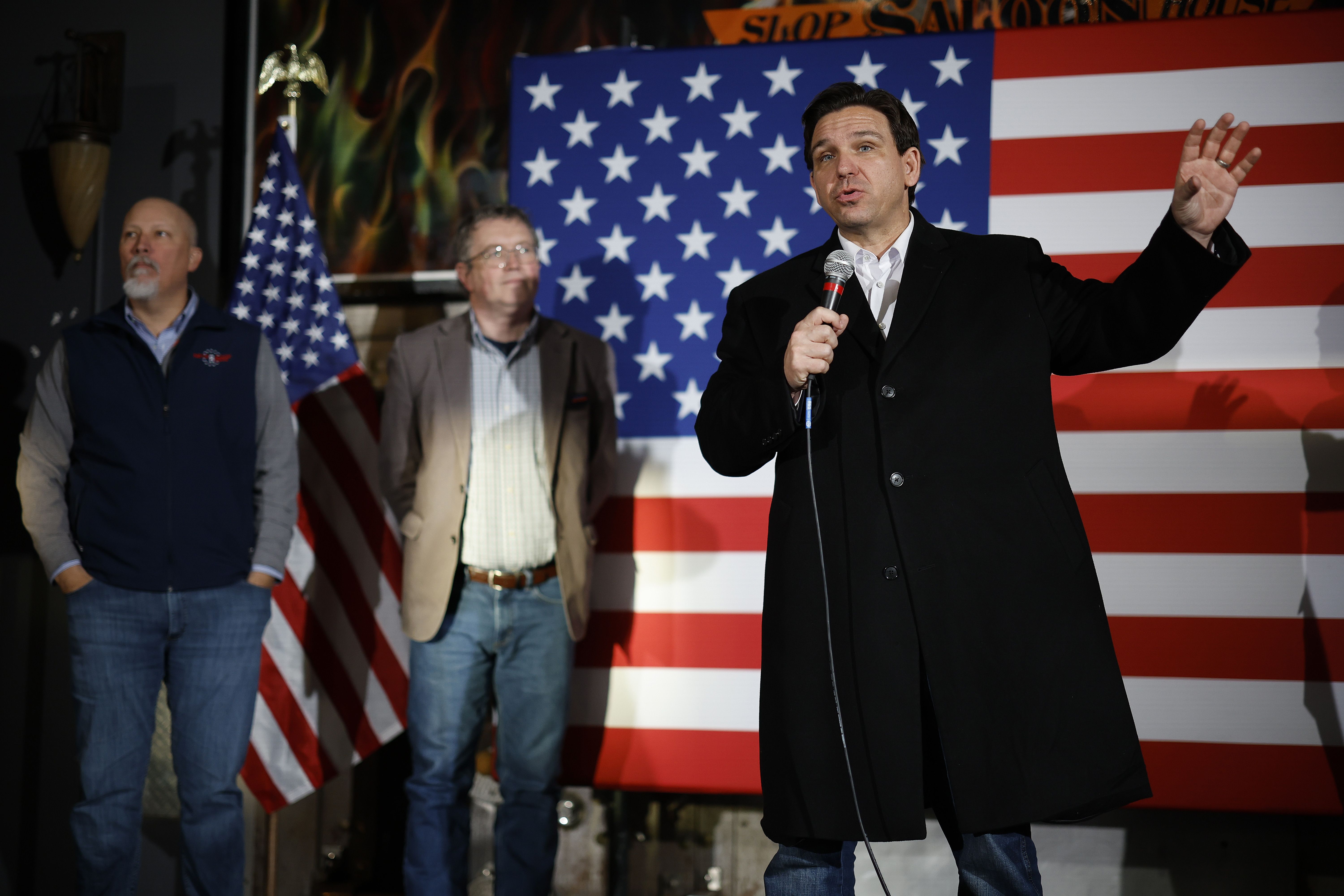 Republican presidential candidate Florida Gov. Ron DeSantis (R) is joined on stage by Rep. Chip Roy (R-TX) (L) and Rep. Thomas Massie (R-KY) (2nd-L) during a campaign event at the Chrome Horse Saloon one day before the Iowa caucuses.