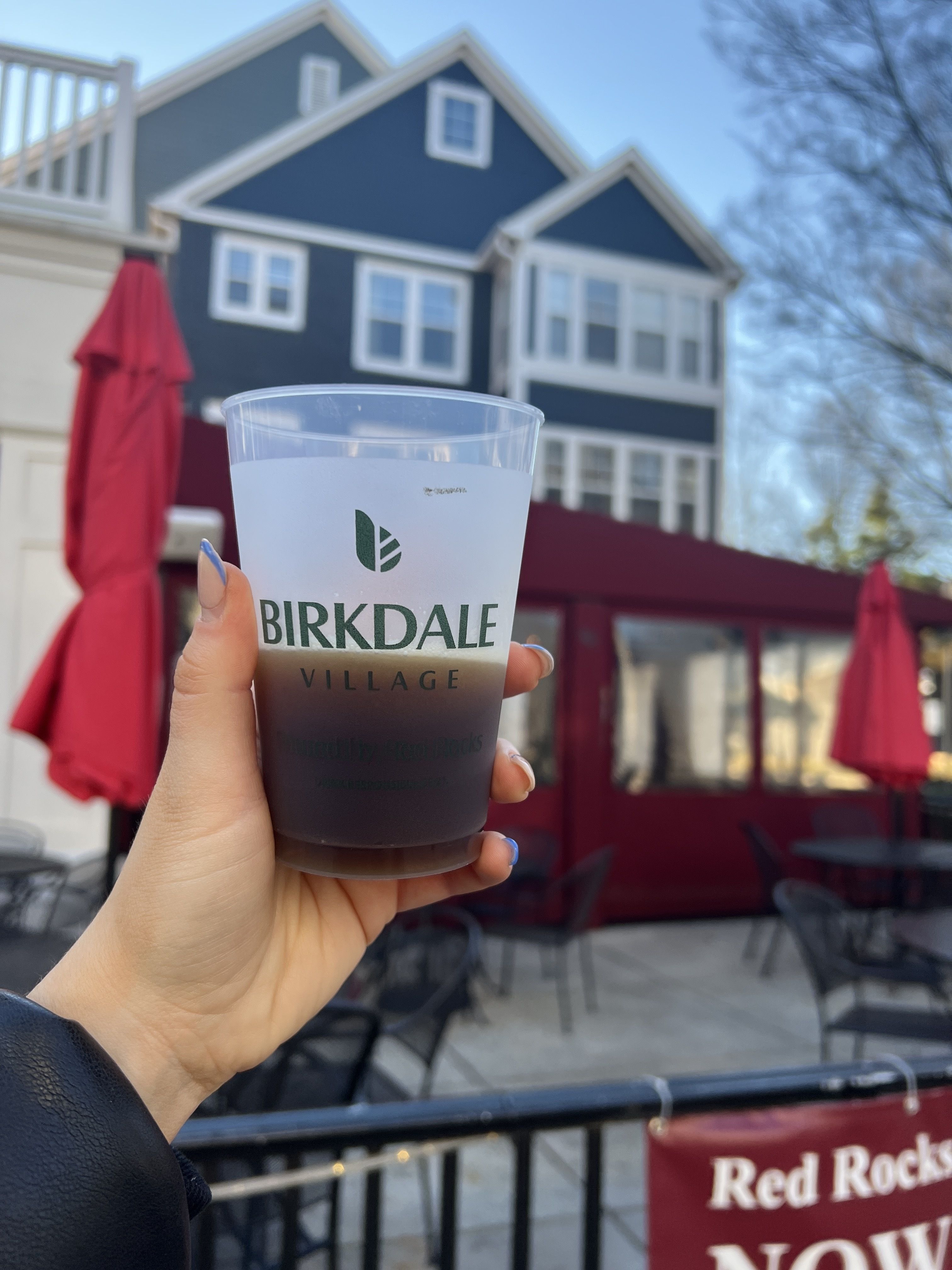 hand holding cup that reads "birkdale village"