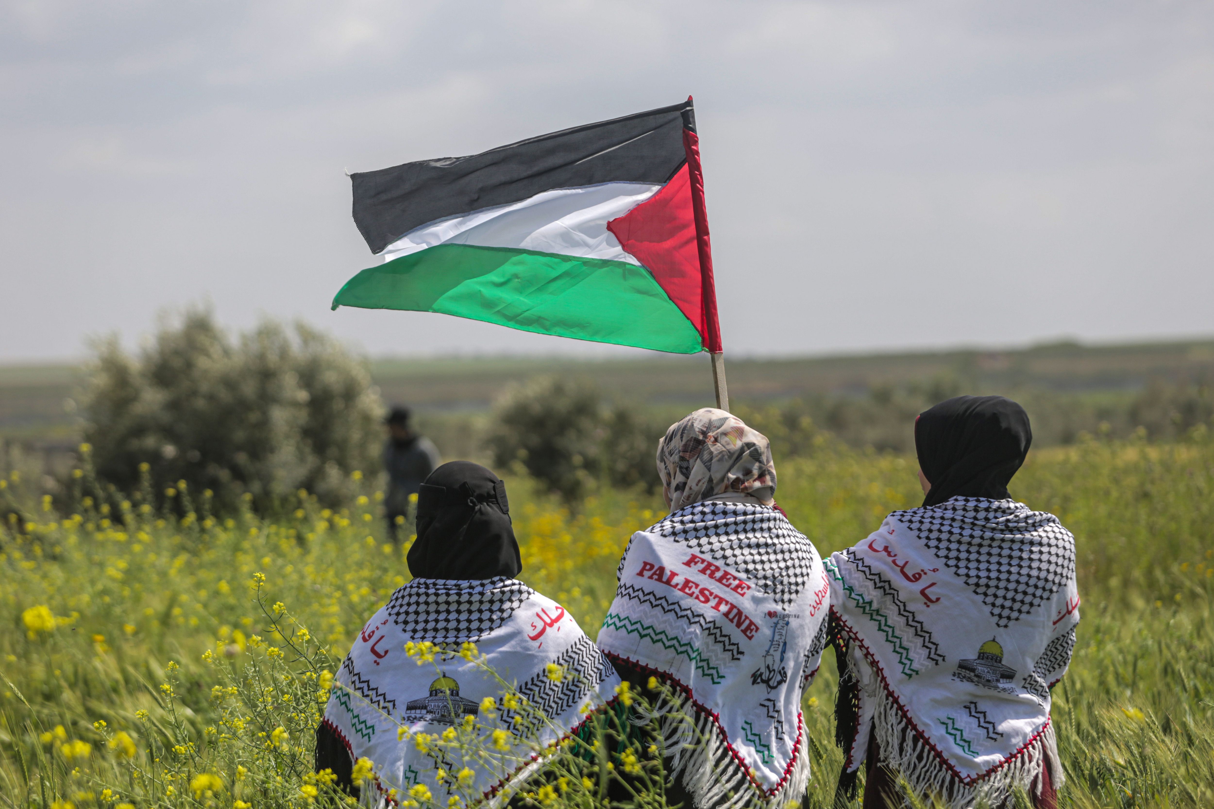  Palestinian holds a flag during a protest marking 'Land Day' along the border between Israel and the Gaza Strip, in the eastern Gaza Strip in March 2023.