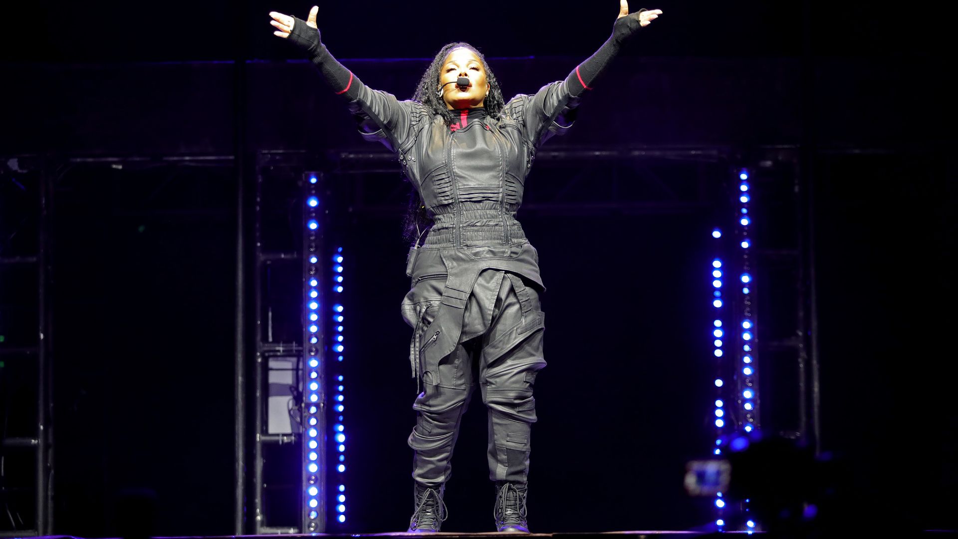 Janet Jackson performs with her arms outstretched above her head