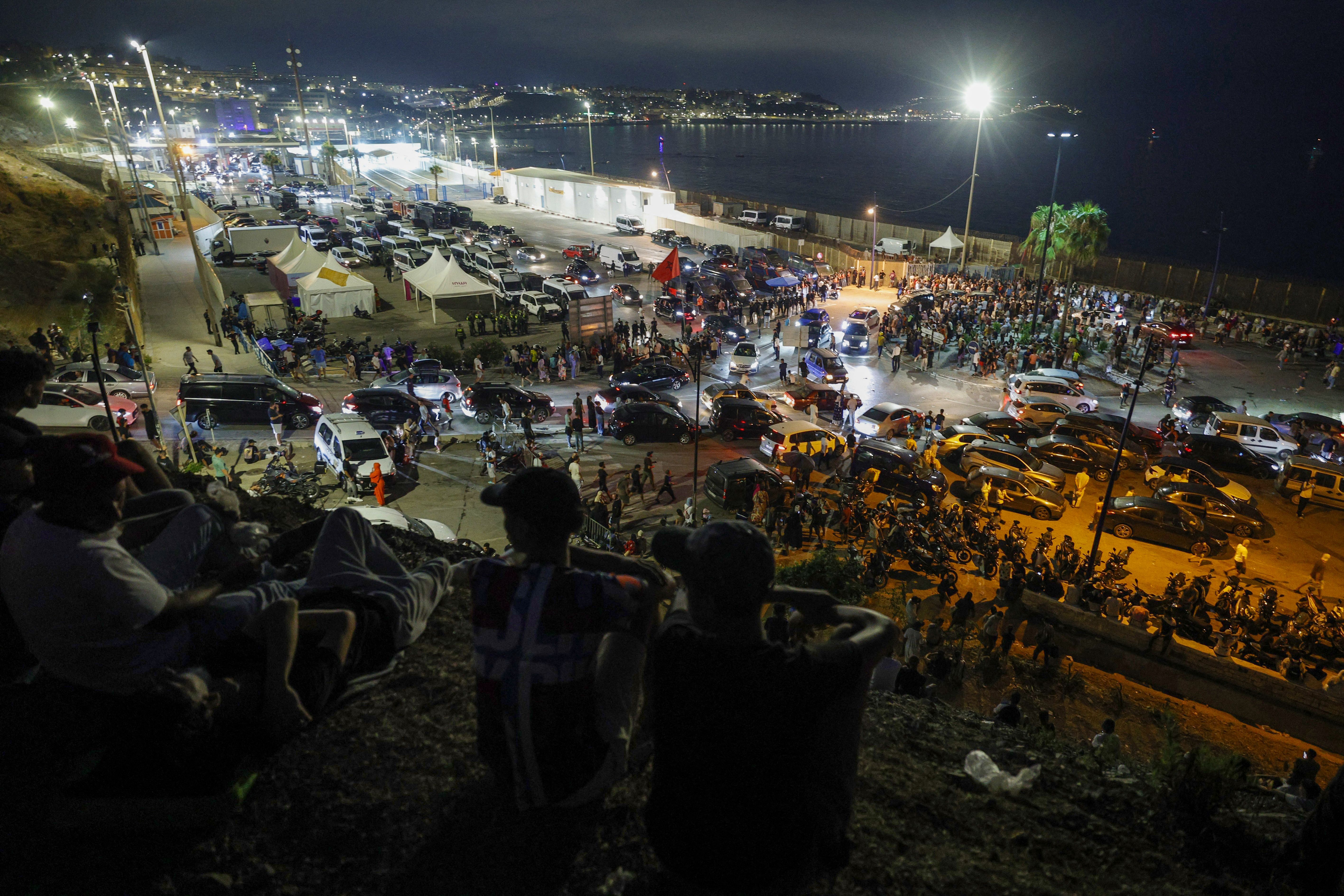 People gather along the border near Spain's enclave of Ceuta and the Moroccan town of Fnideq yesterday. Photo: Abdelmajid Bziouat/AFP via Getty Images
