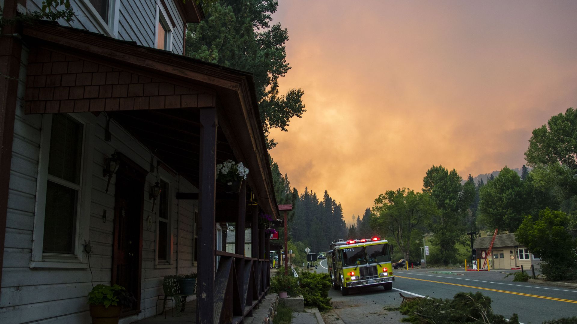 Firefighters are seen working to protect a town as the Tamarack fire continues to burn through more than 21,000 acres in California Saturday.