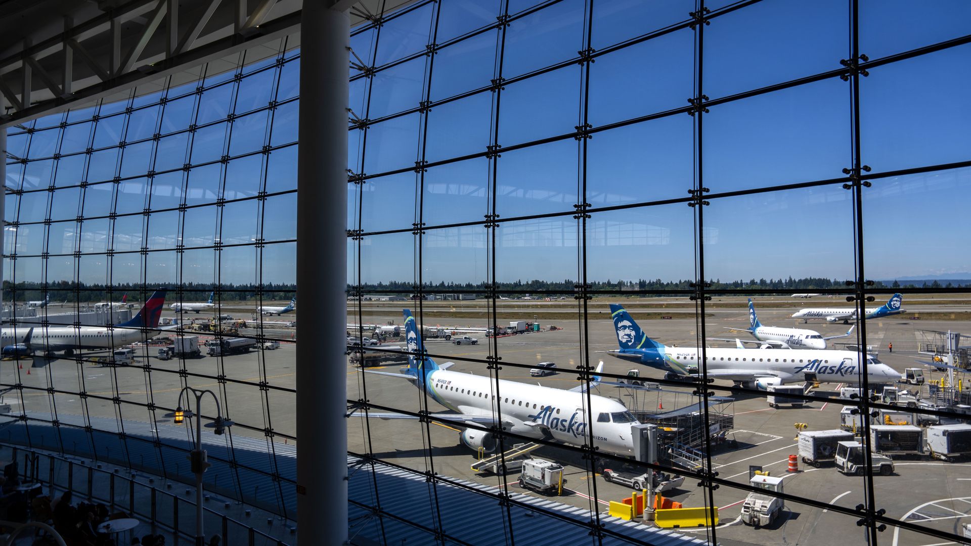 A view of an airport tarmac as seen through panes of glass from inside a terminal. 