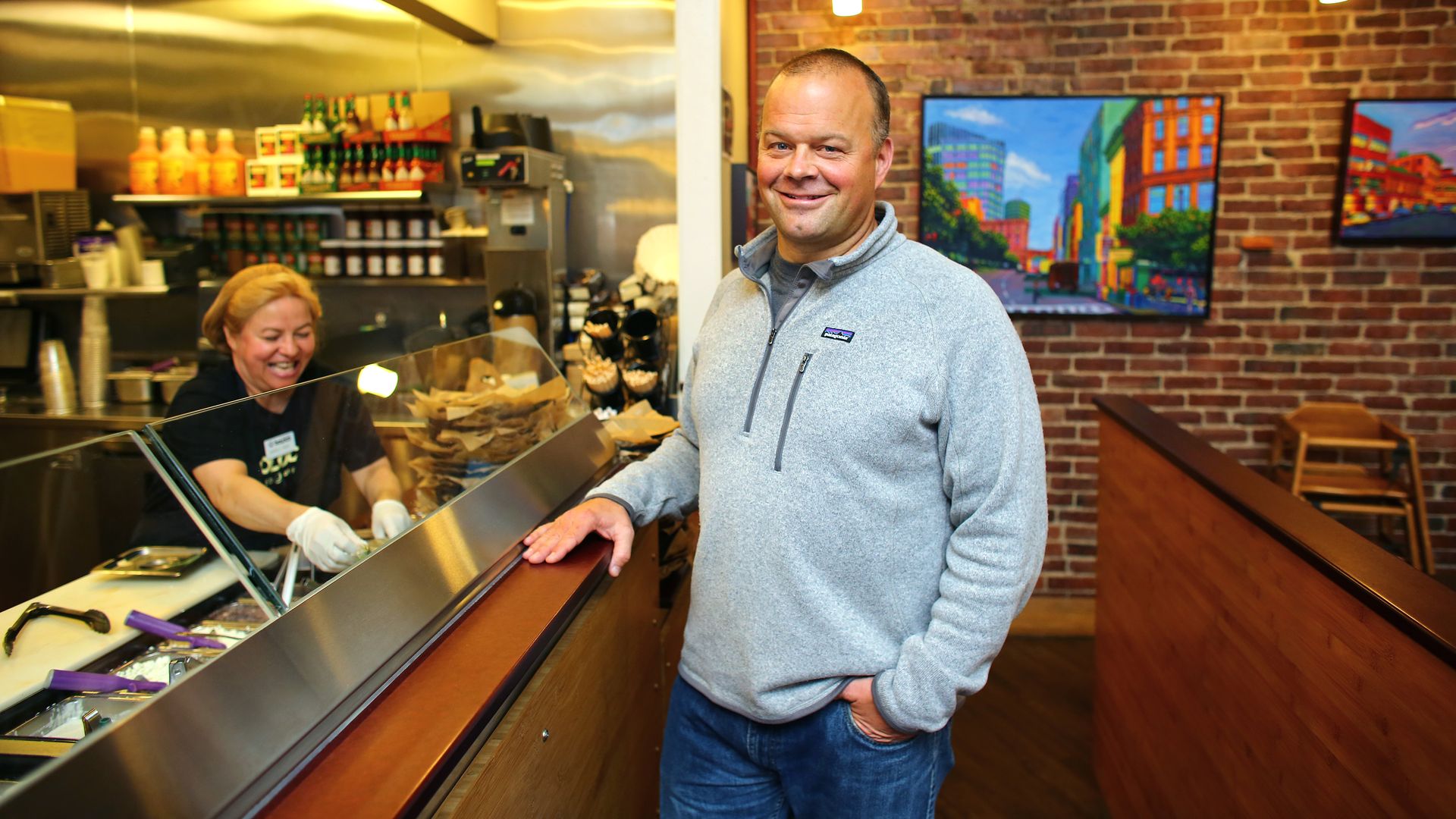 Boloco co-founJohn Pepper, right,  stands in front of the ordering counter near line cook Aracelly Haque, at the Boylston street location of the fast-food restaurant, on Wednesday, October 1, 2014. 