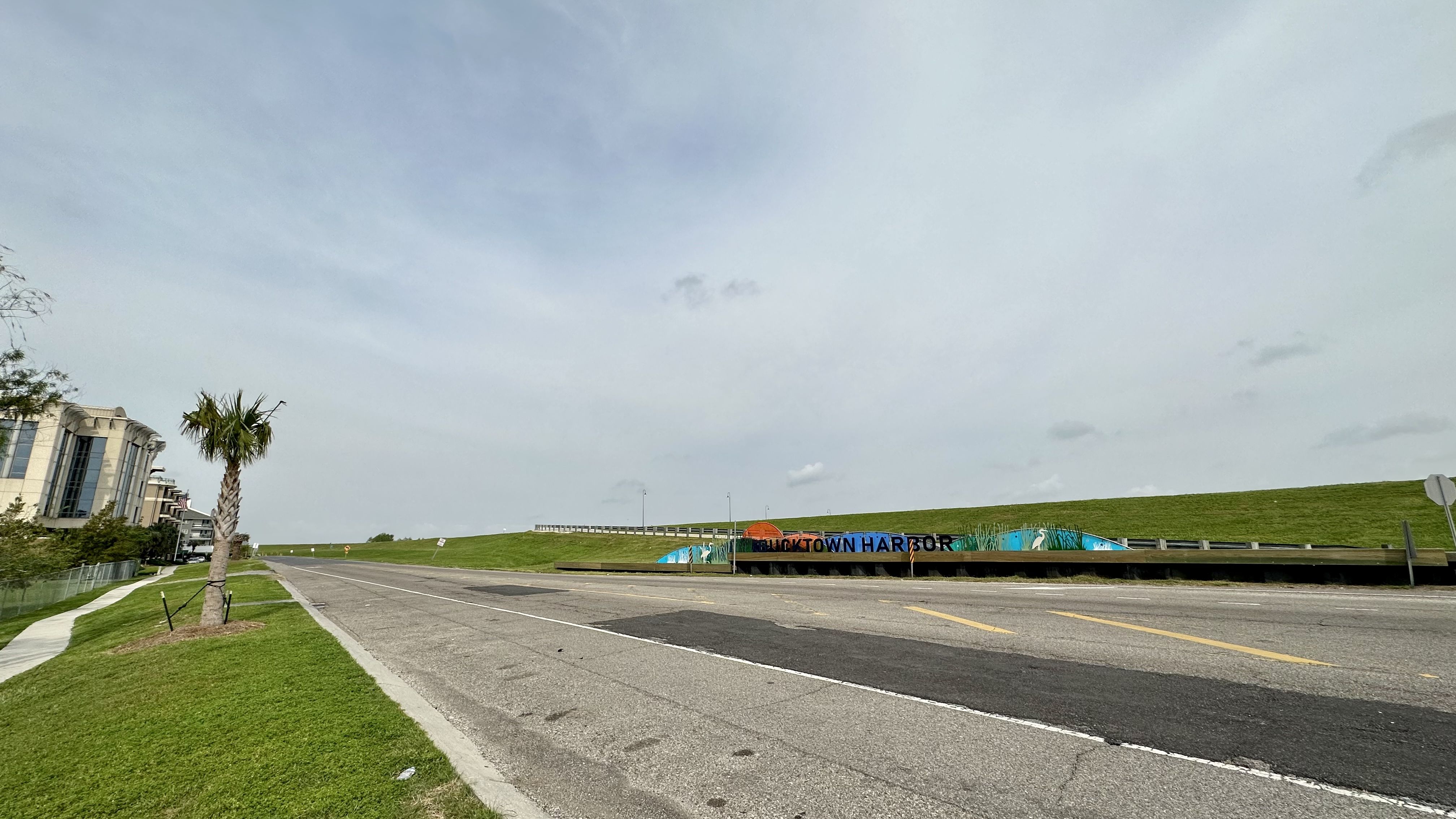 Photo shows a road with a sign on the right that says "Bucktown Harbor."