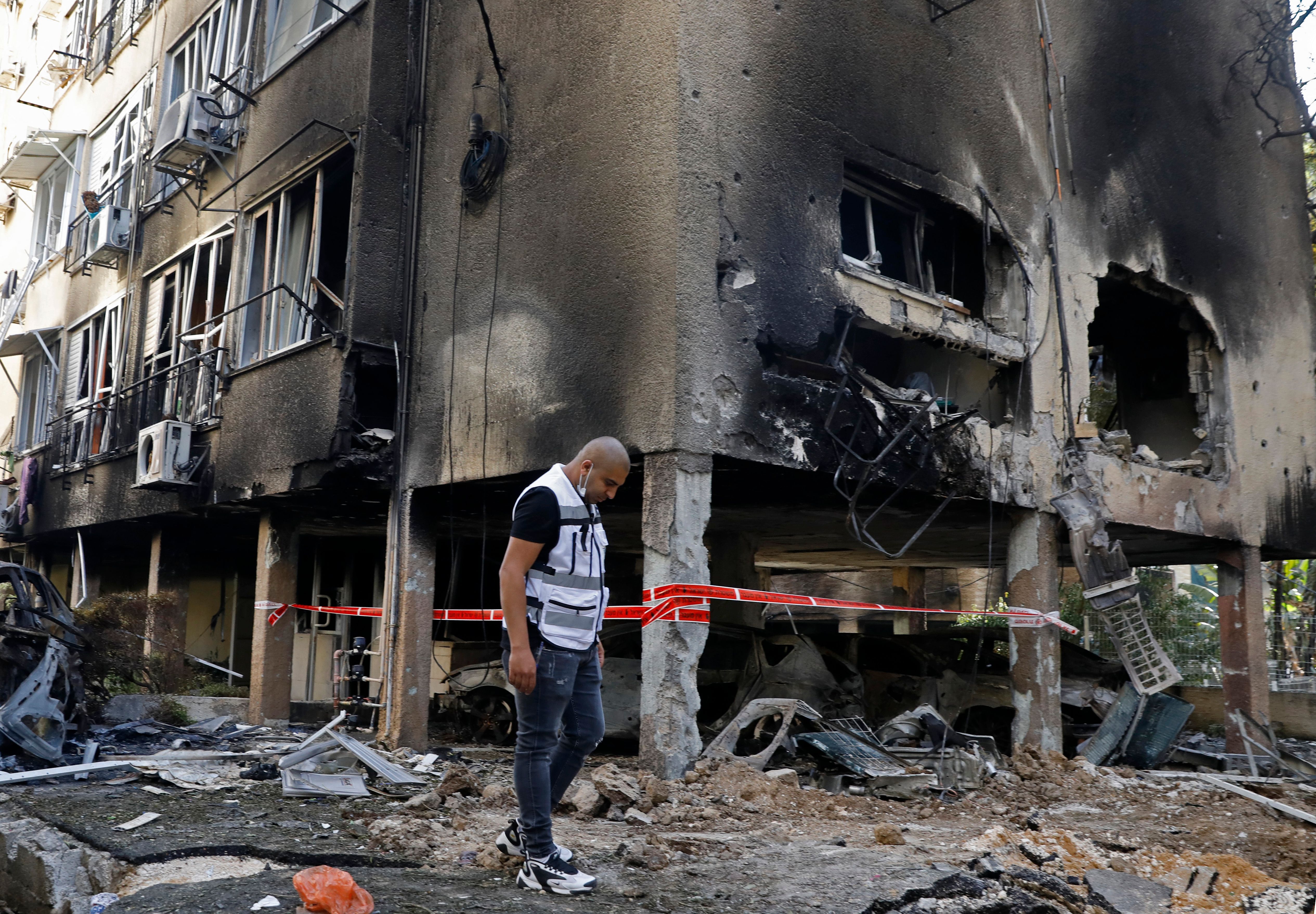 An Israeli man checks the damages after a rocket attack from the Hamas-controlled Gaza Strip, in the central Israeli city of Petah Tikva, on May 13