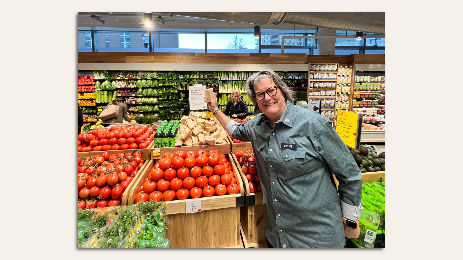 Cathy Strange, a Whole Foods executive, stands in front of a display of tomatoes and cheese.
