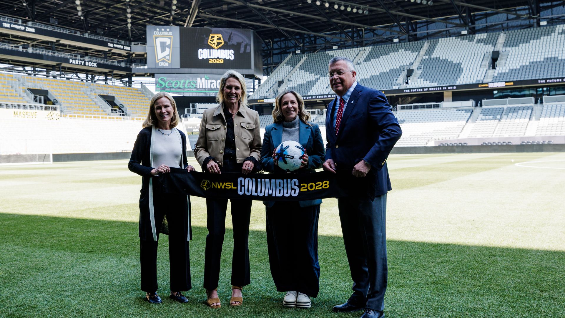 Ownership group leaders and NWSL Commissioner Jessica Berman stand on the field at ScottsMiracle-Gro Field