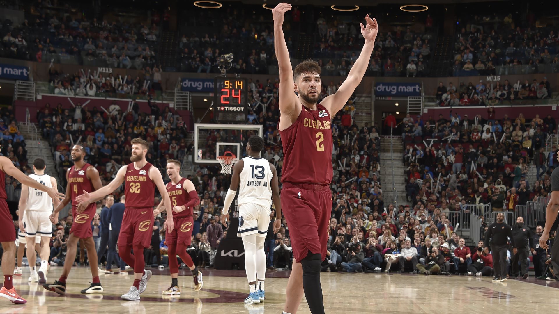 Ty Jerome in red cavs jersey raising hands to crowd