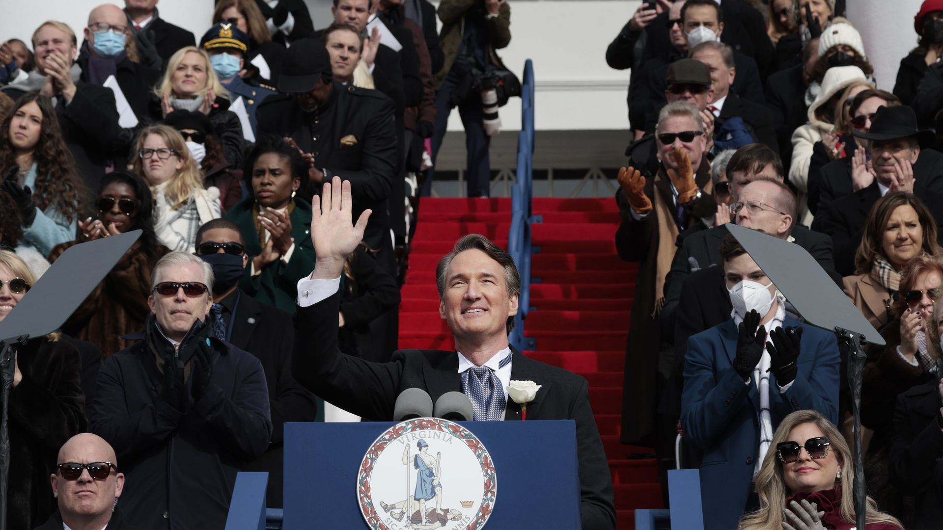 Glenn Youngkin waves in front of a clapping crowd during his inauguration.