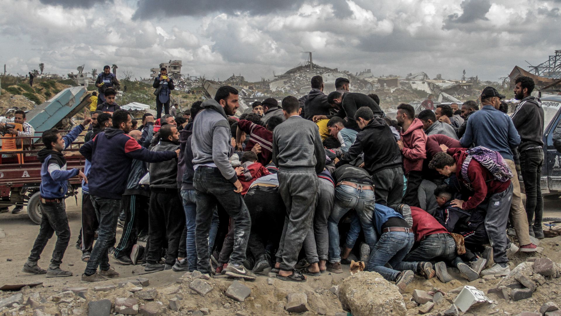 Dozens of people around packages of humanitarian aid airdropped over Jabalia in northern Gaza Strip in March 2024.