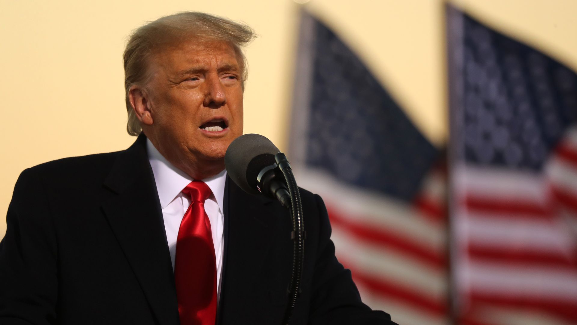 donald trump in front of flags