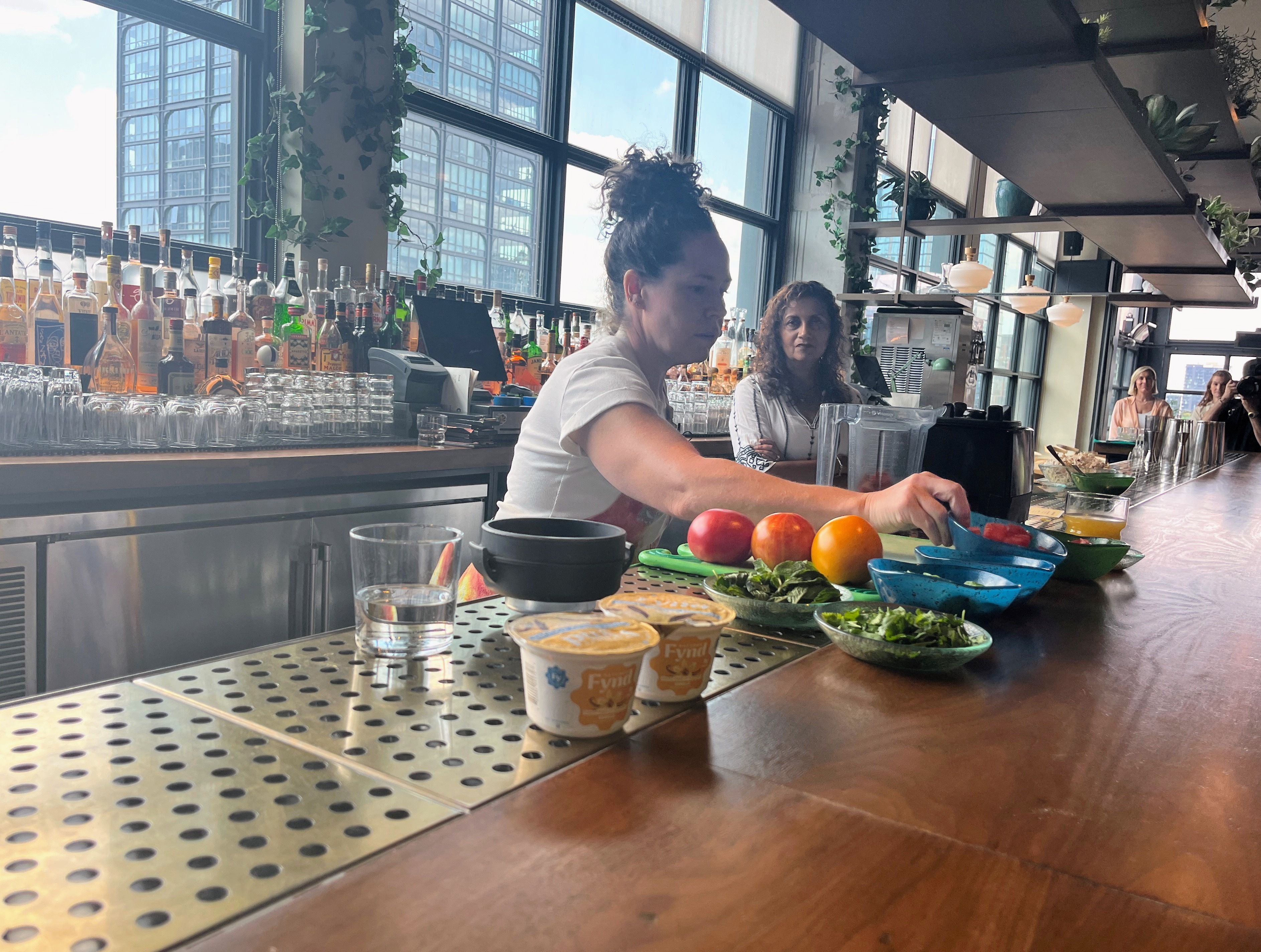 Photo of a woman behind a bar at a restaurant. 