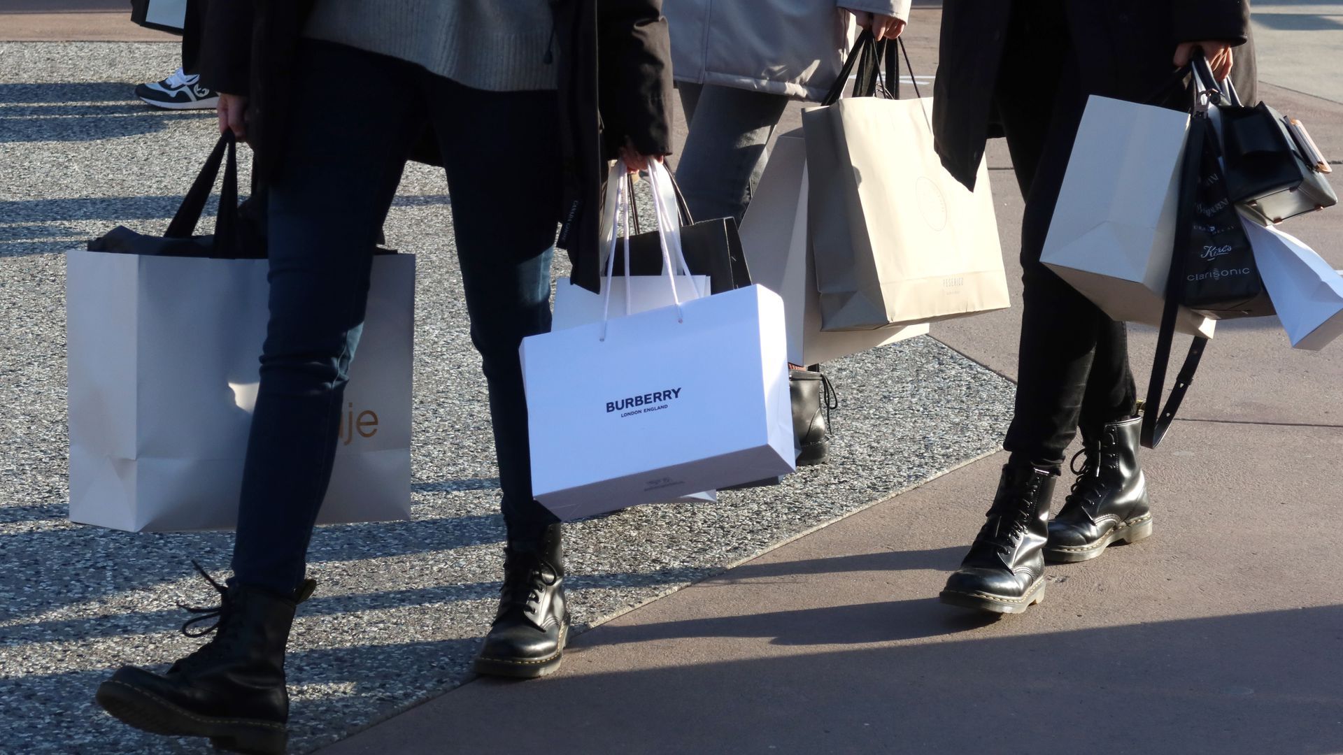 Illustration of a person carrying shopping bags.