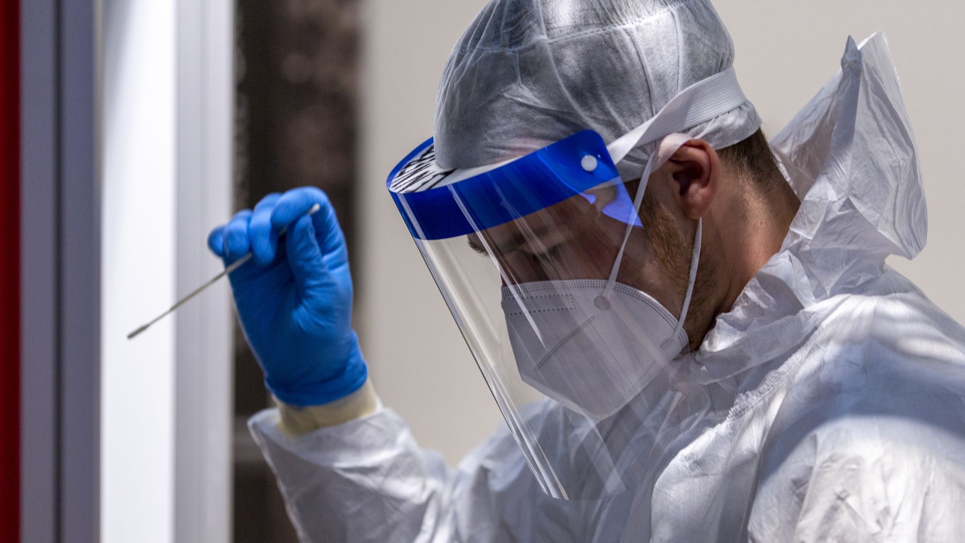 Photo of a medical worker holding a COVID-19 throat swab sample 