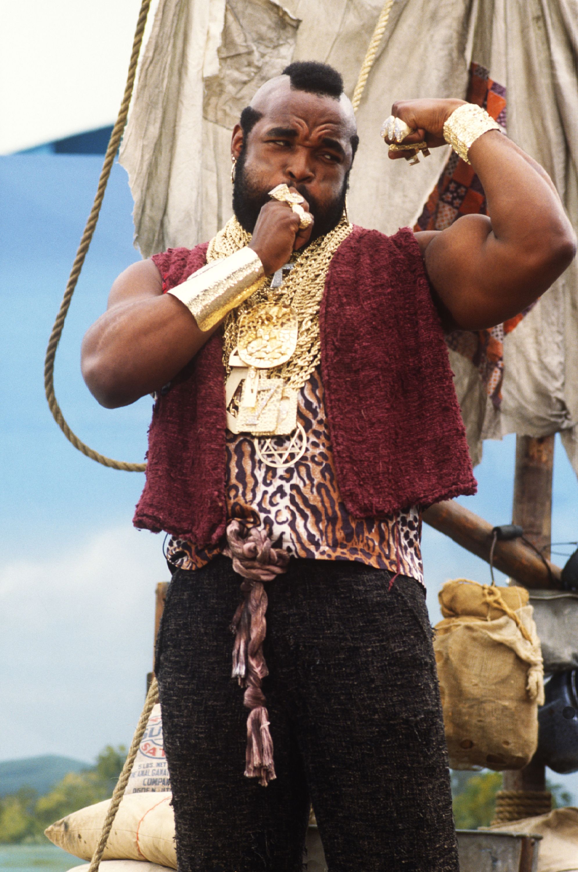 Photo shows Mr. T flexing his arm and wearing gold necklaces.