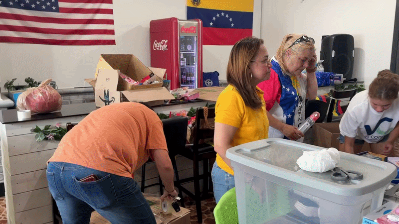 a video of people organizing donations with a venezuelan flag in the back