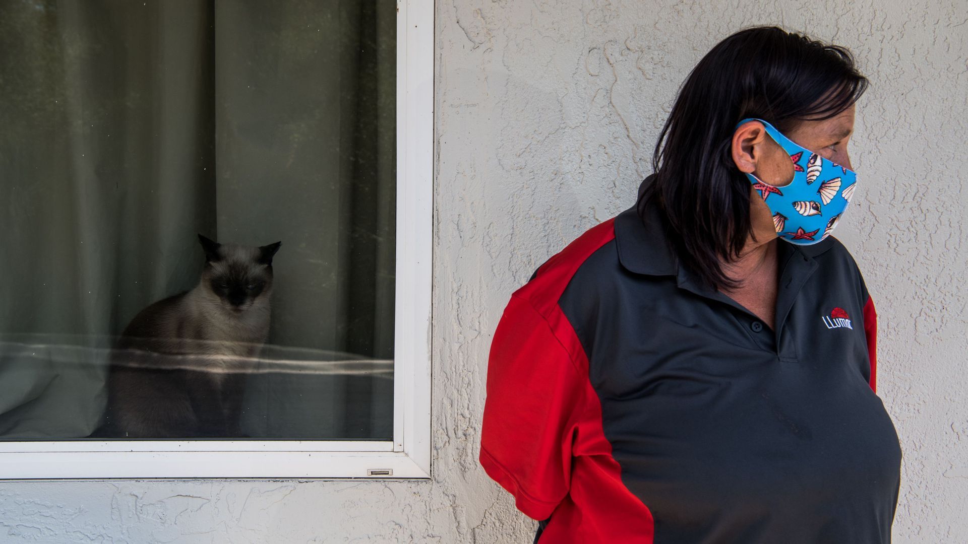 Photo of a masked woman staring off to the side