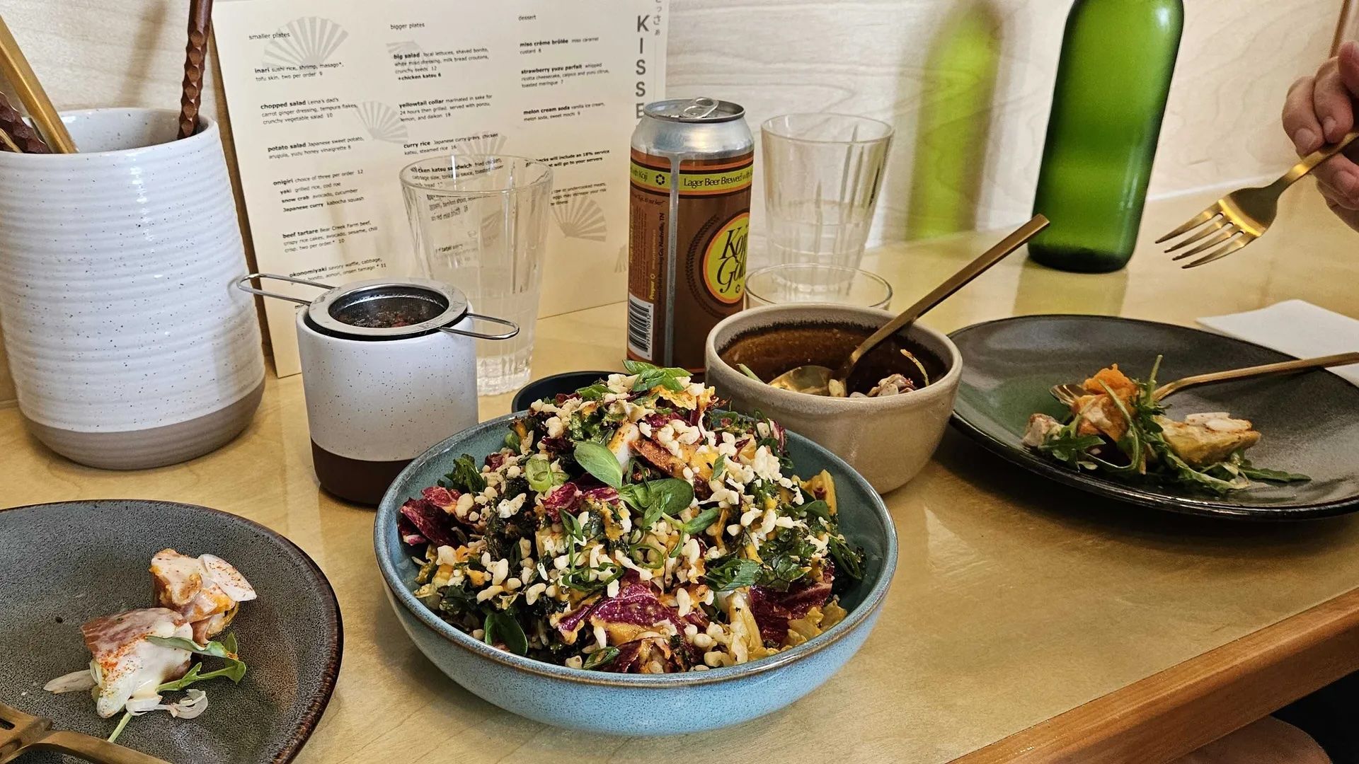 A salad surrounded by other lunch plates.
