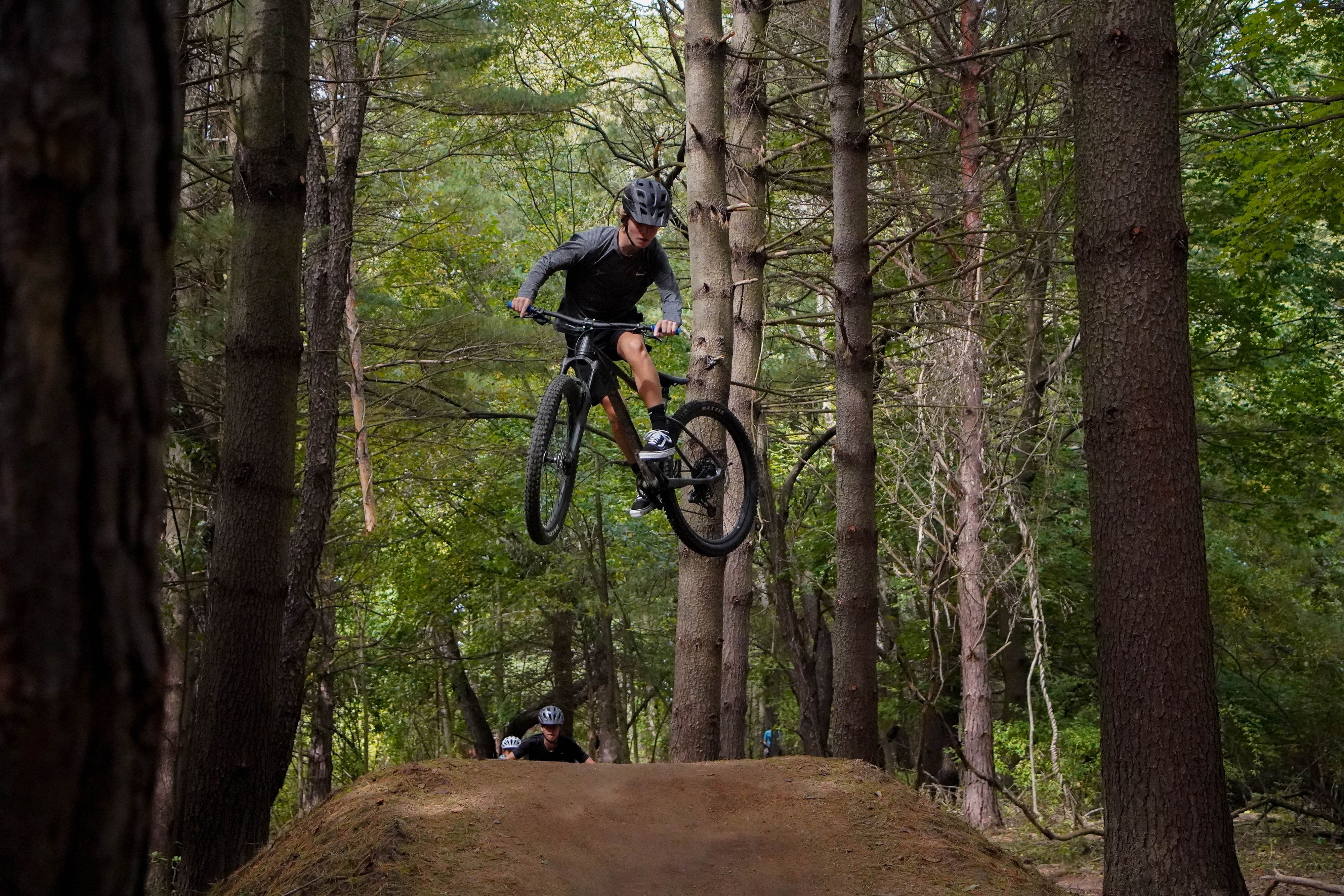 A mountain bike rider gets massive air on a trail. 