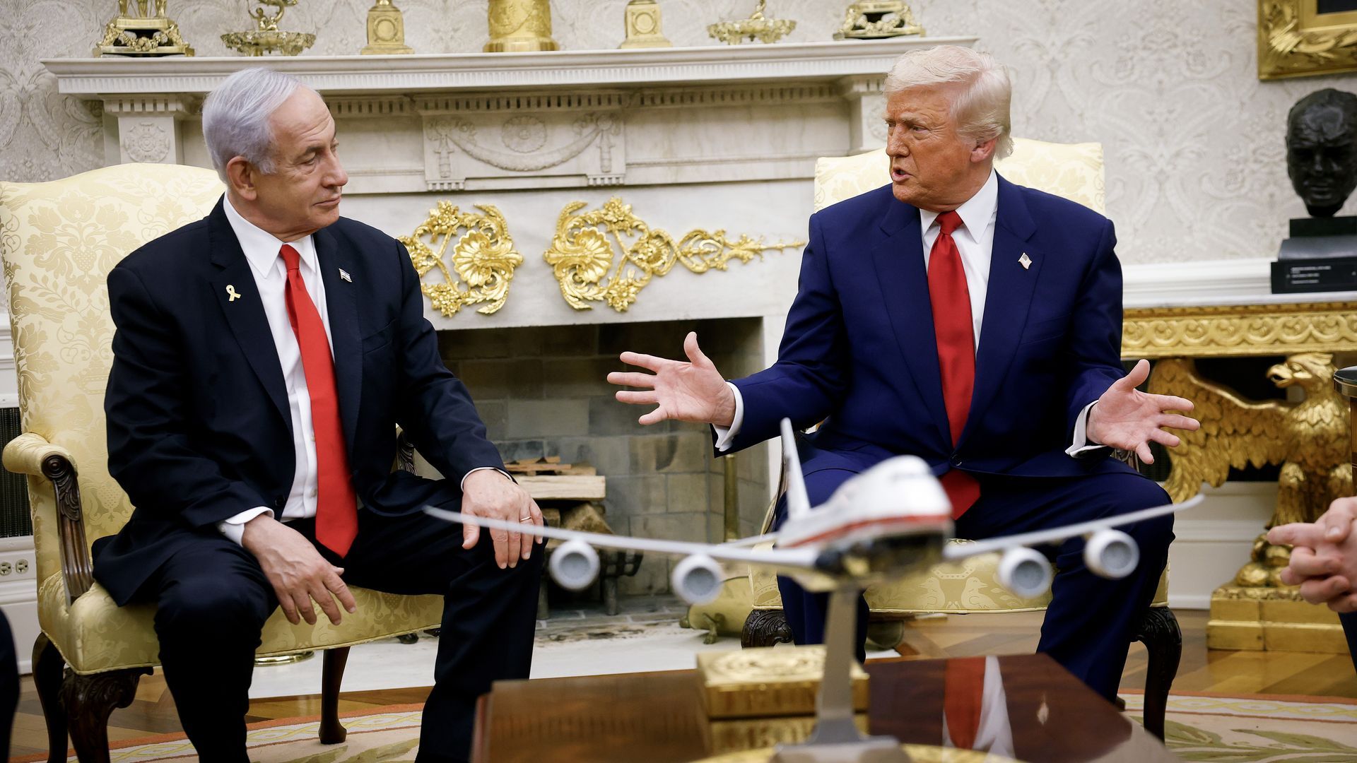 Two men in red ties sitting in yellow chairs