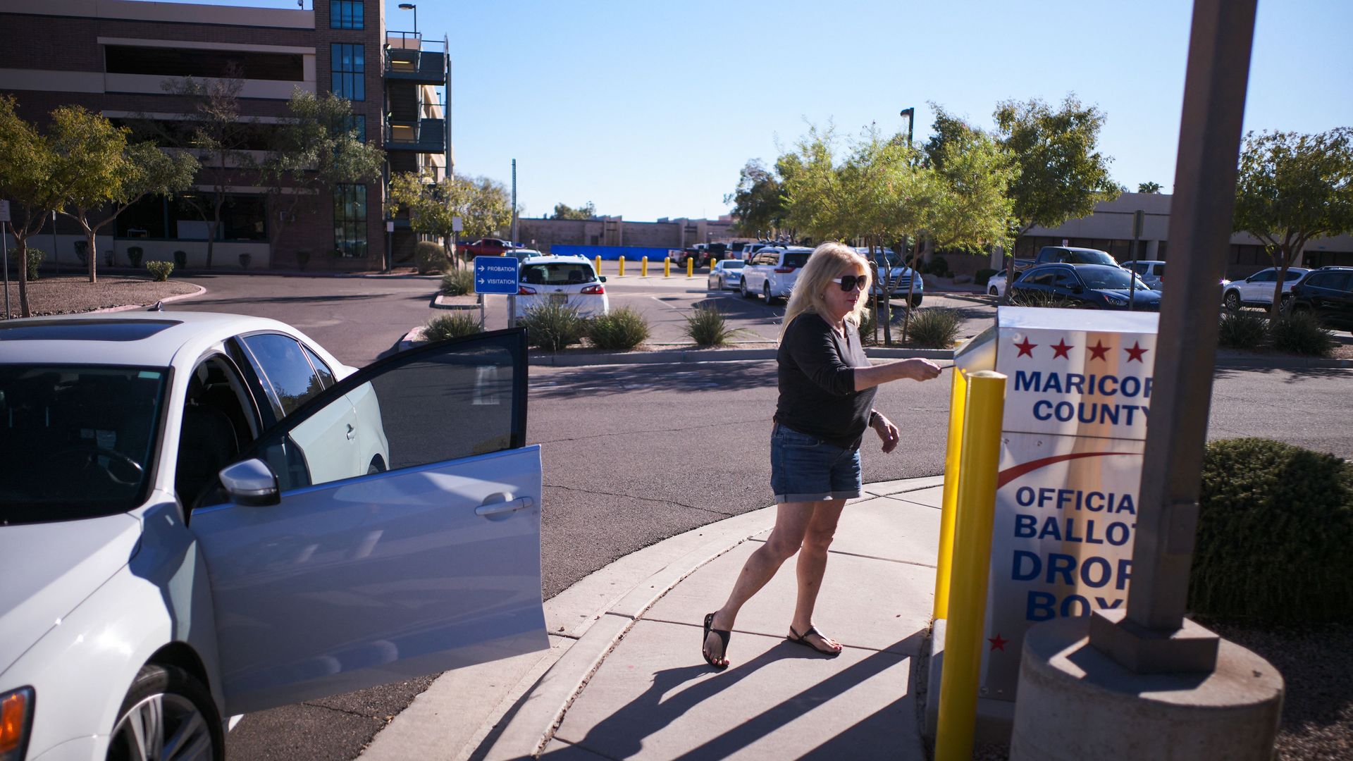 A woman drops her ballot for the upcoming midterm elections in the drop box near the Maricopa County Juvenile Court Center in Mesa, Arizona on October 25.