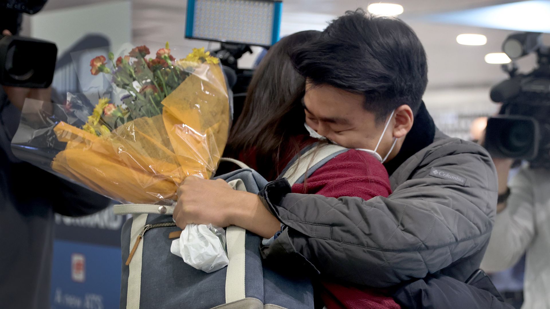 Yerin Hong gets a hug from her boyfriend, Soomin Kim, after she arrived on a flight from Germany at O'Hare International Airport on November 08, 2021 in Chicago, Illinois.