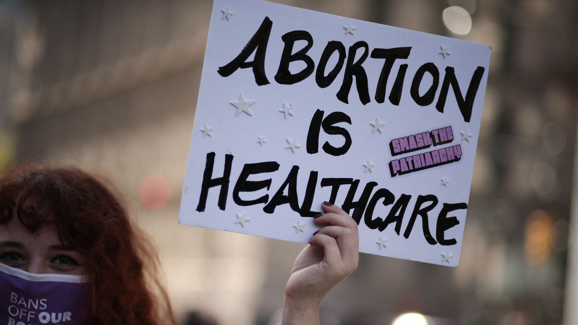 Picture of a person carrying a sign that says "abortion is health care"
