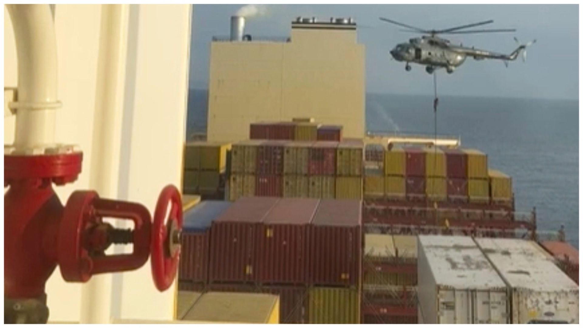 Iranian military helicopter hovers over an Israeli-affiliated container ship near the Strait of Hormuz 
