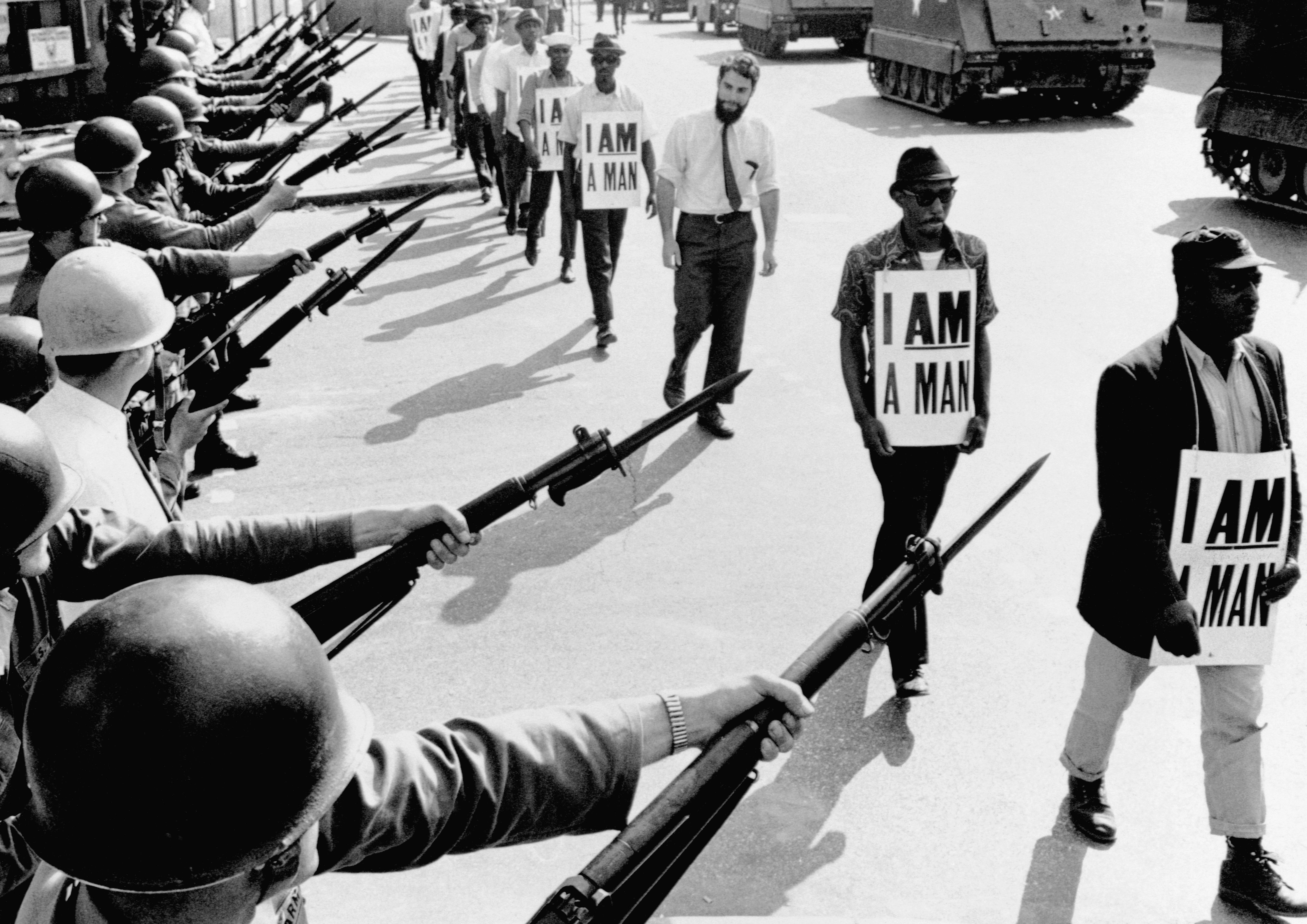 Civil Rights activists blocked by National Guardsmen with bayonets. The marching demonstrators, who are wearing signs which say "I Am A Man,"