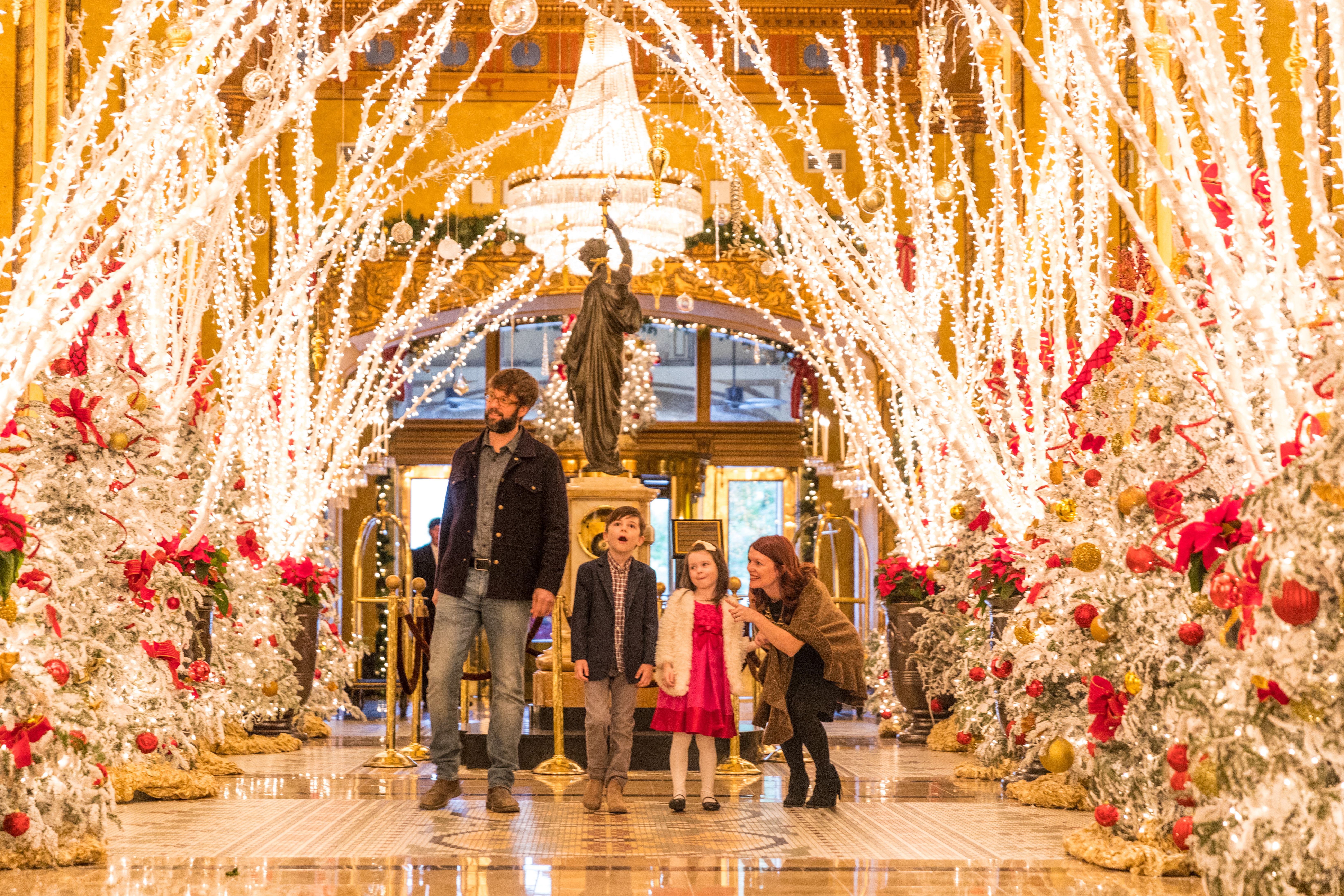Photo shows a family in the decorated lobby of The Roosevelt.