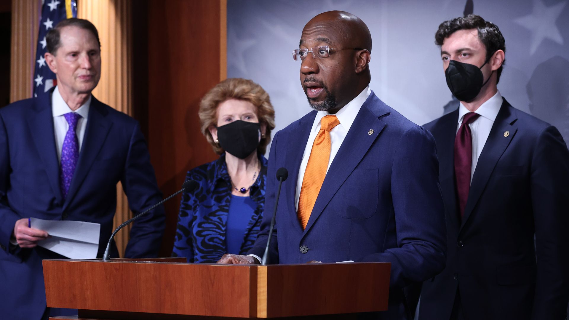 Sen. Warnock at a podium in front of fellow Senators
