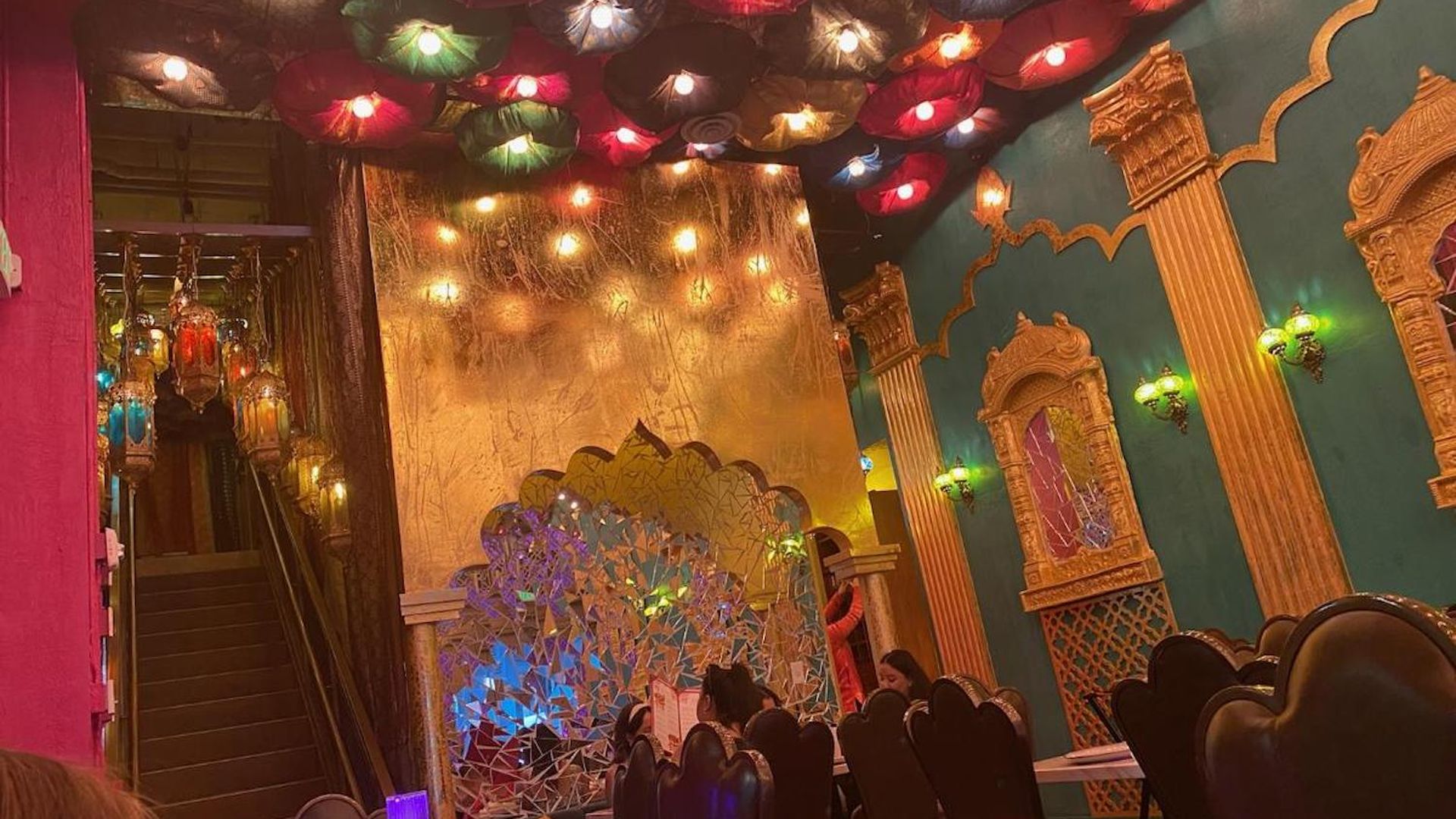 A restaurant with colorful lights and gold accents 