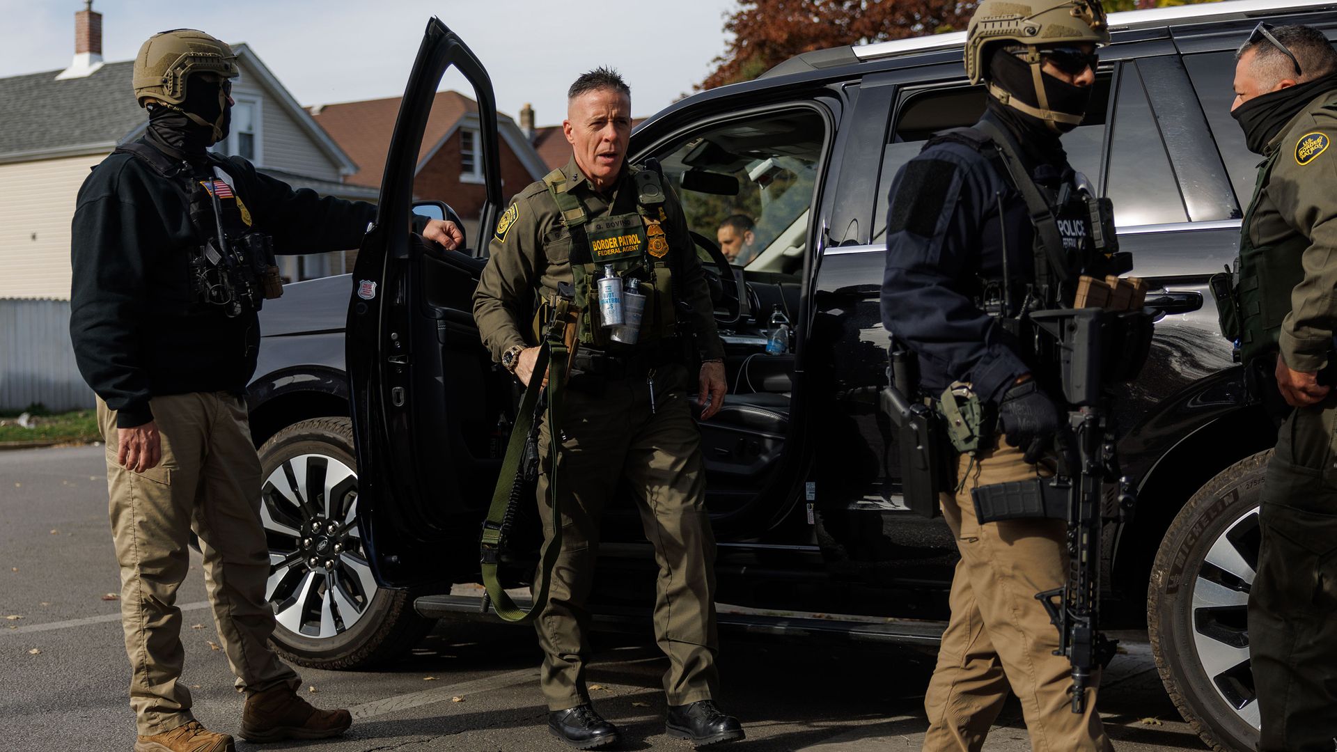 Border Patrol stand in front a car, ready to conduct an immigration enforcement action