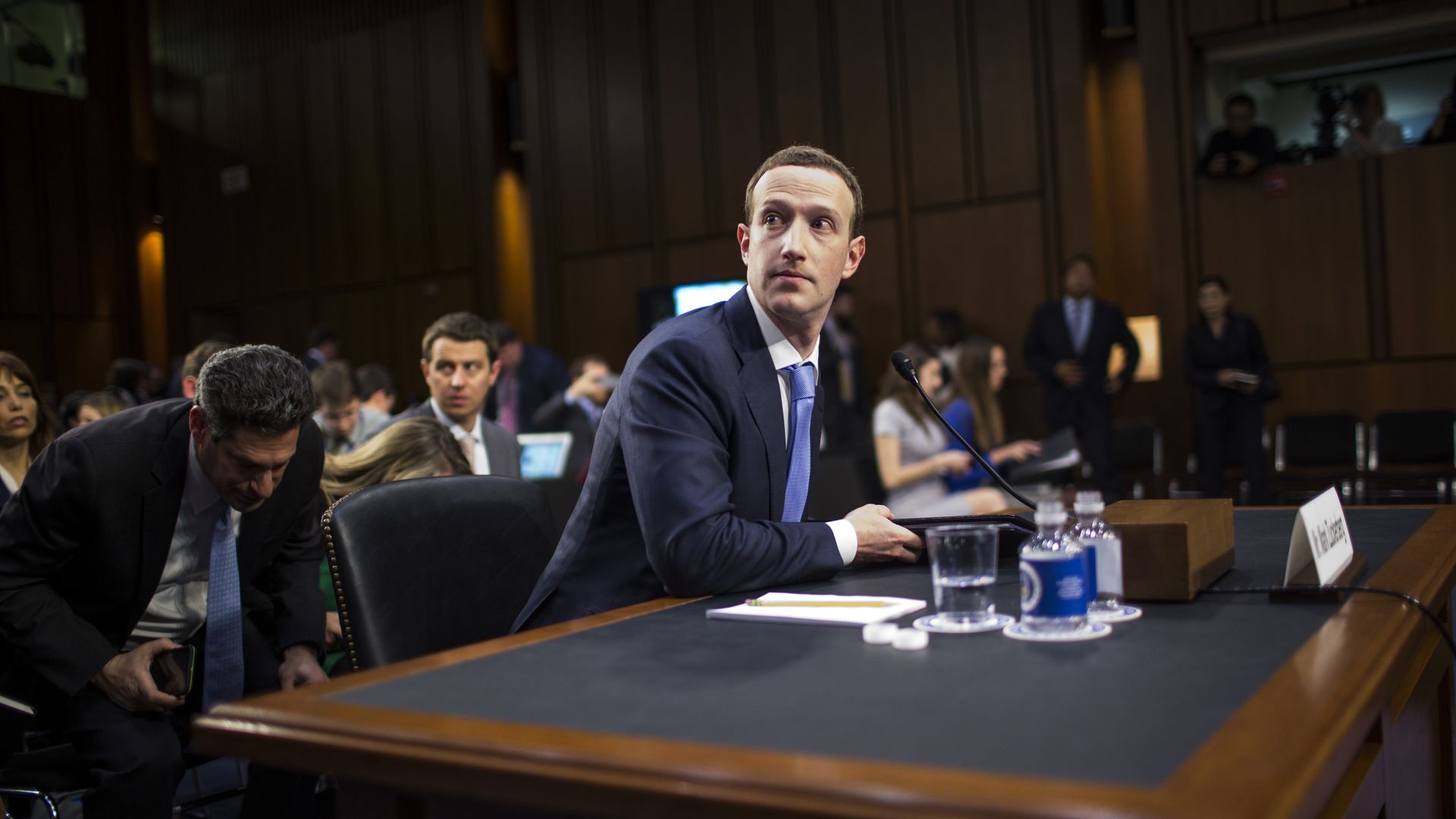 A man looks off to the side while sitting at a desk