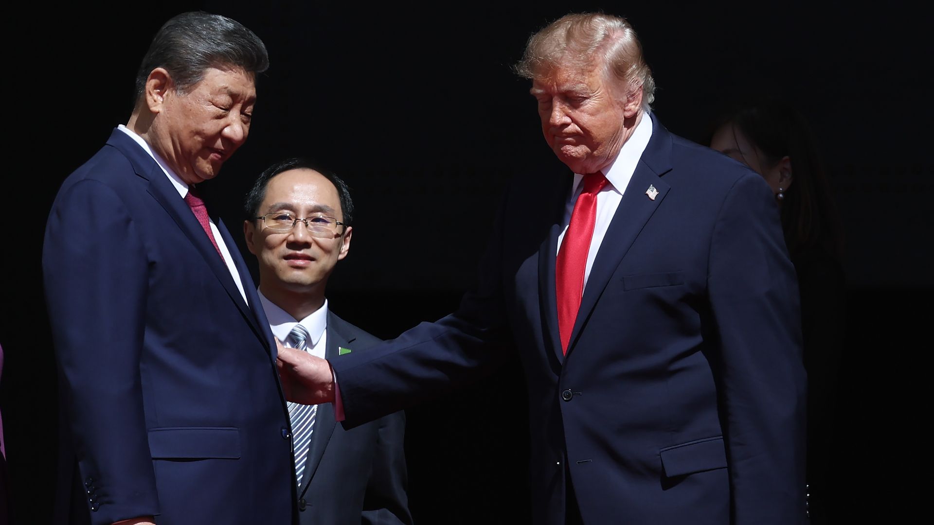 President Trump puts his right hand on the left arm of China's Xi Jinping.