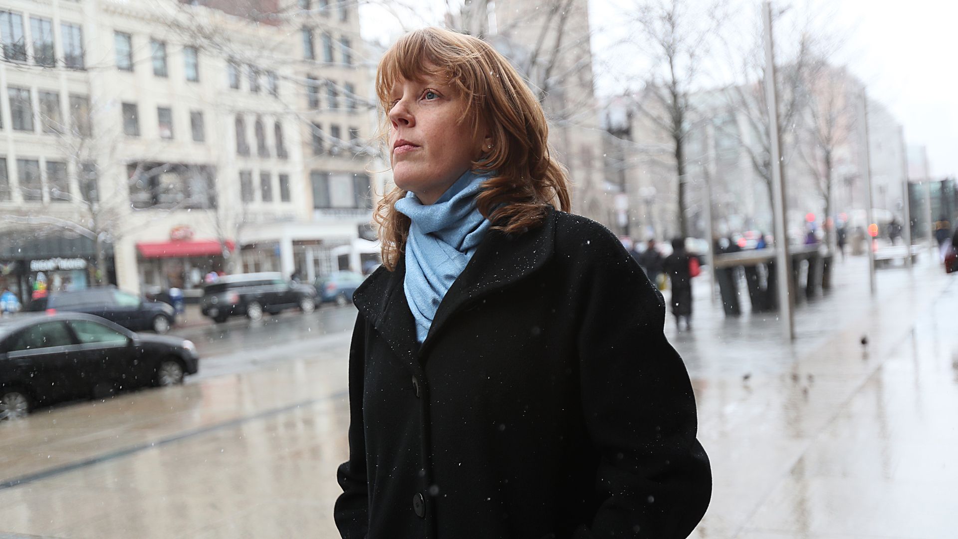 Marathon bombing survivor Manya Chylinski walks outside in a black coat and blue scarf. She inspired Rep. Pressley to change the law over what mental health funding governments get after disasters.