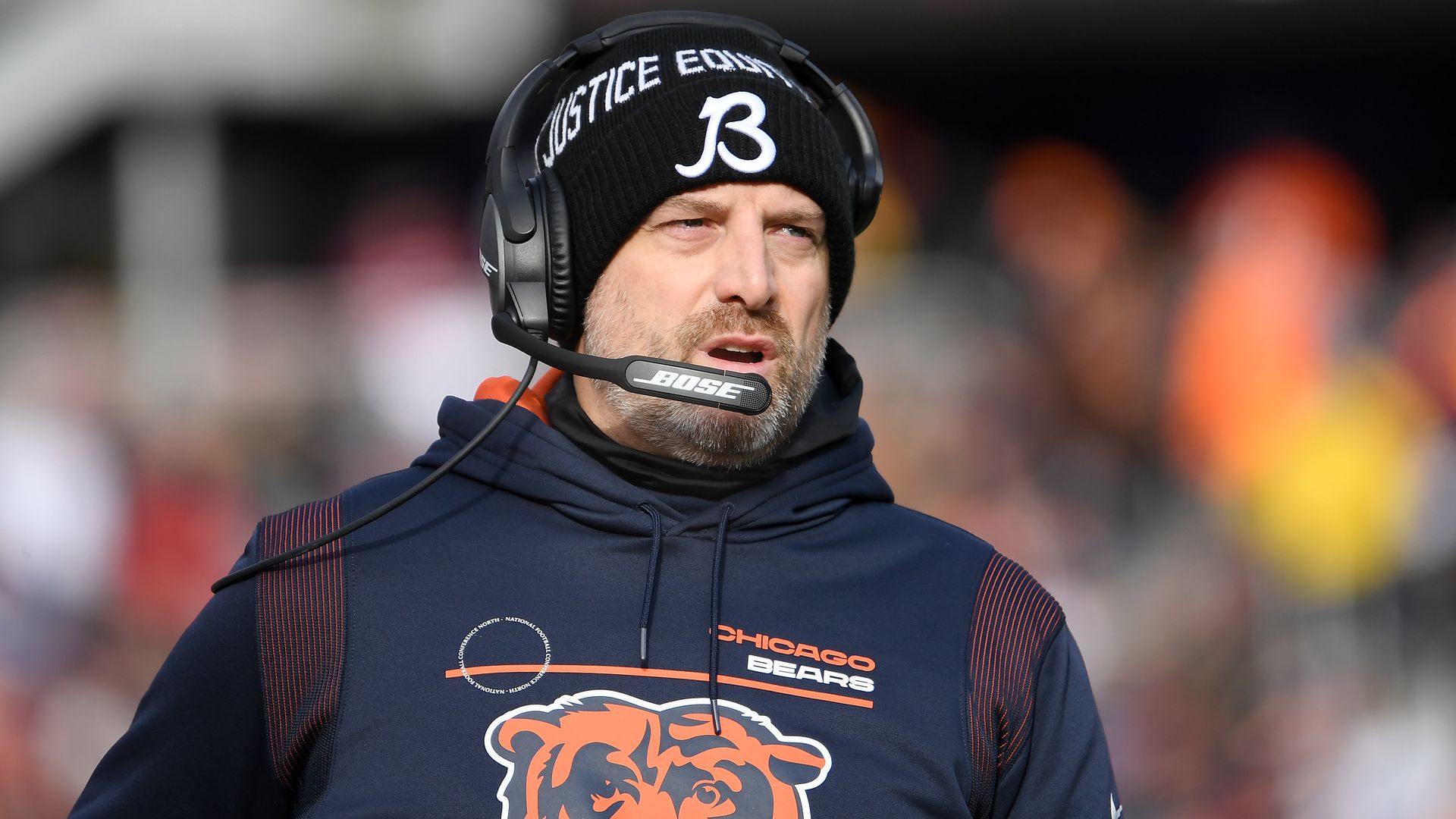 A photo of a coach on the sidelines of a football game. 