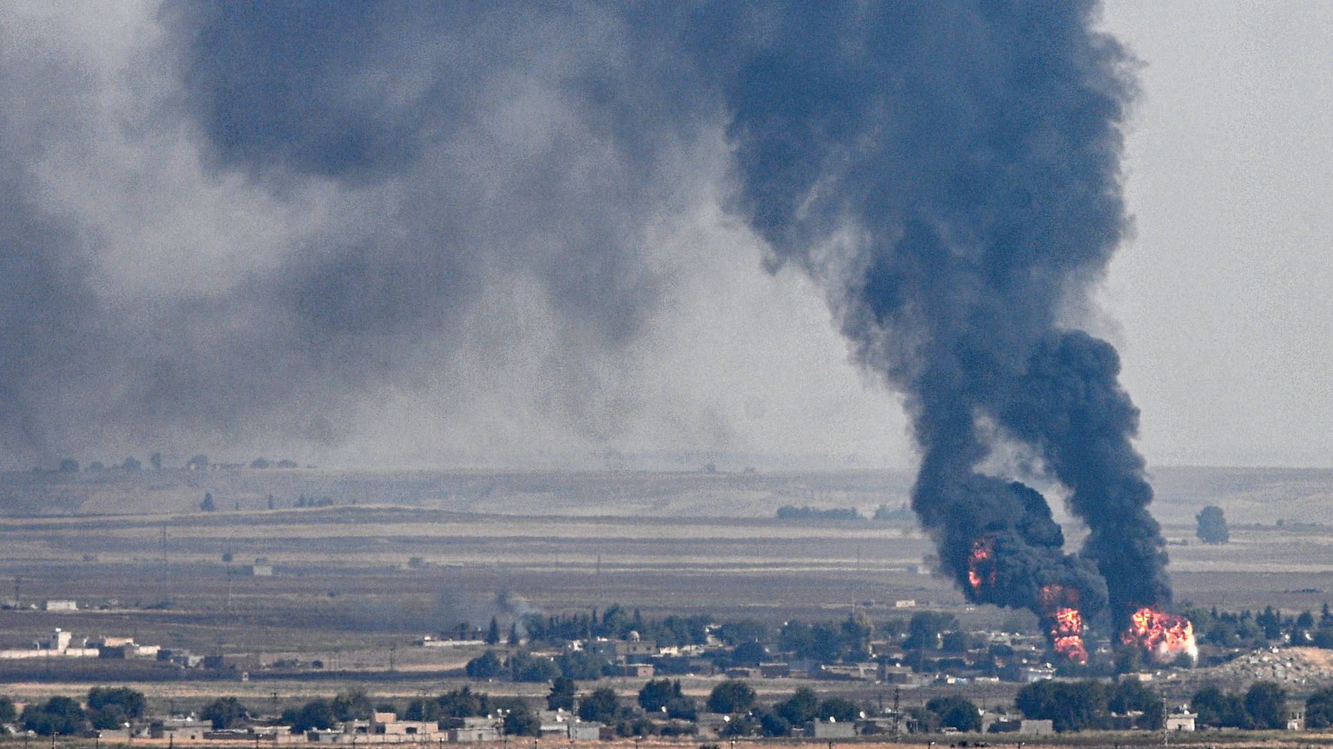 black smoke rising over a town