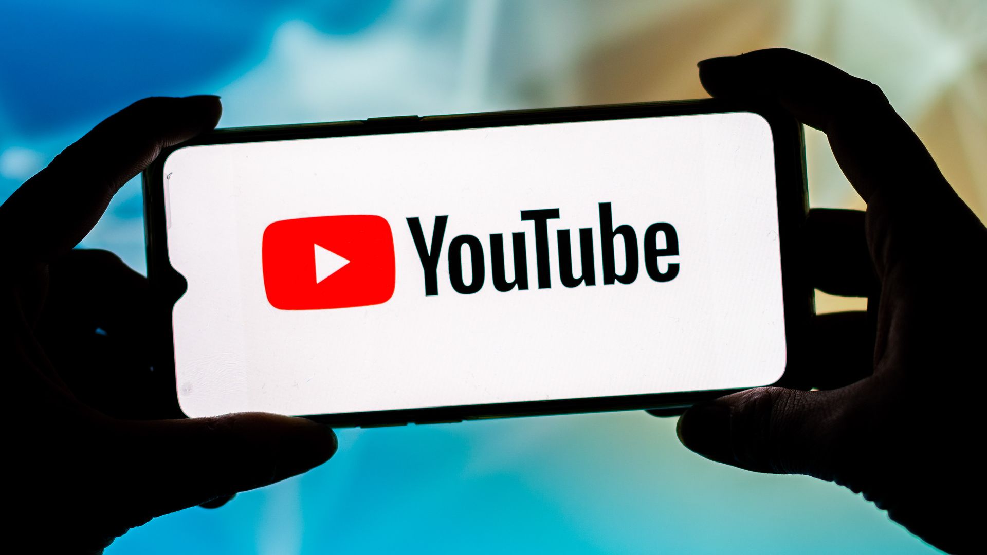 The YouTube logo is shown on a mobile phone