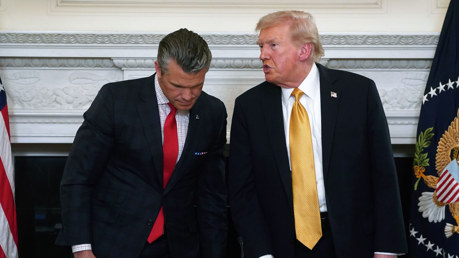 Hegseth leans over as Trump speaks