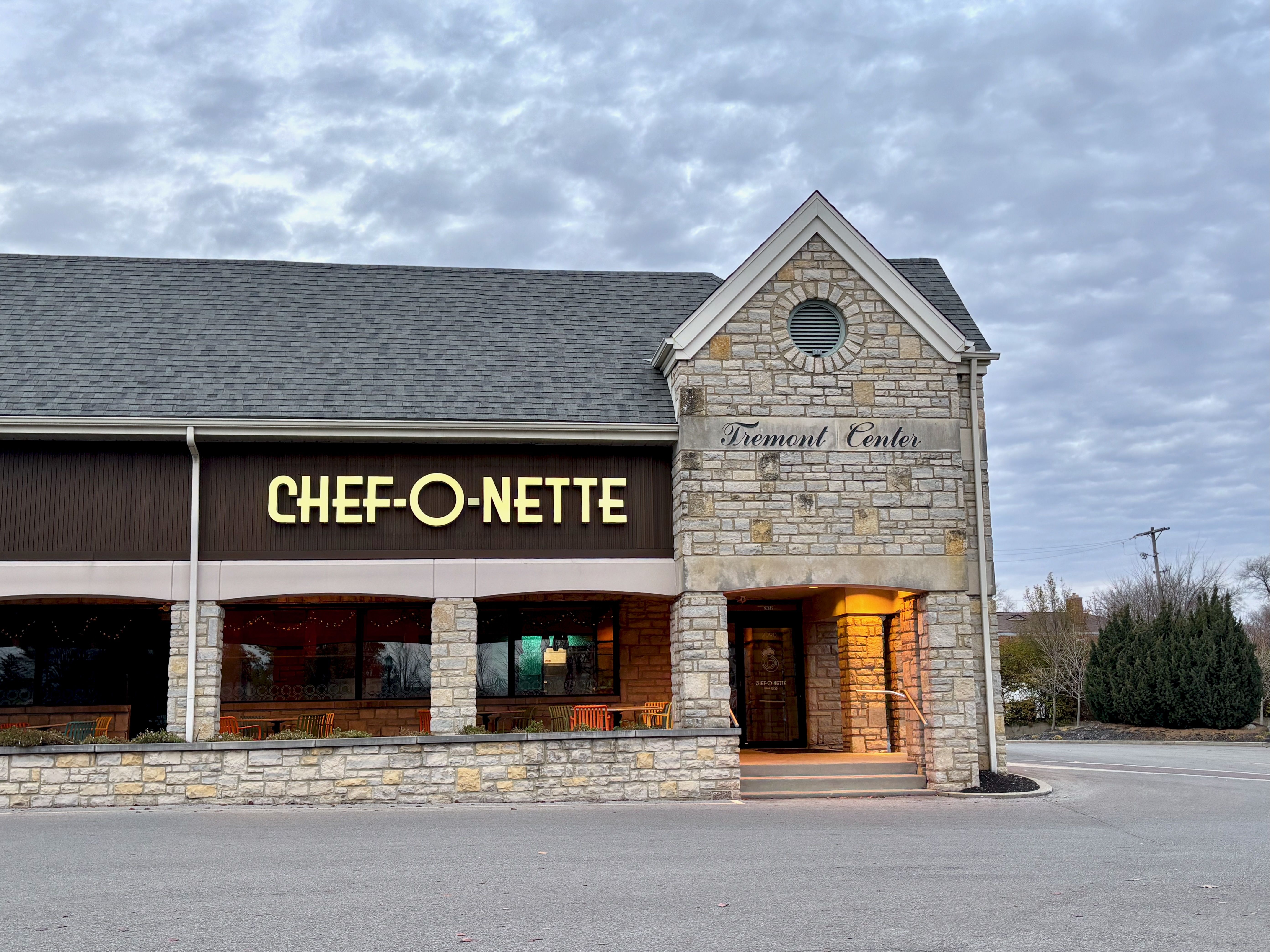 The exterior of Chef-O-Nette, with the restaurant's name in neon letters on a brick building.