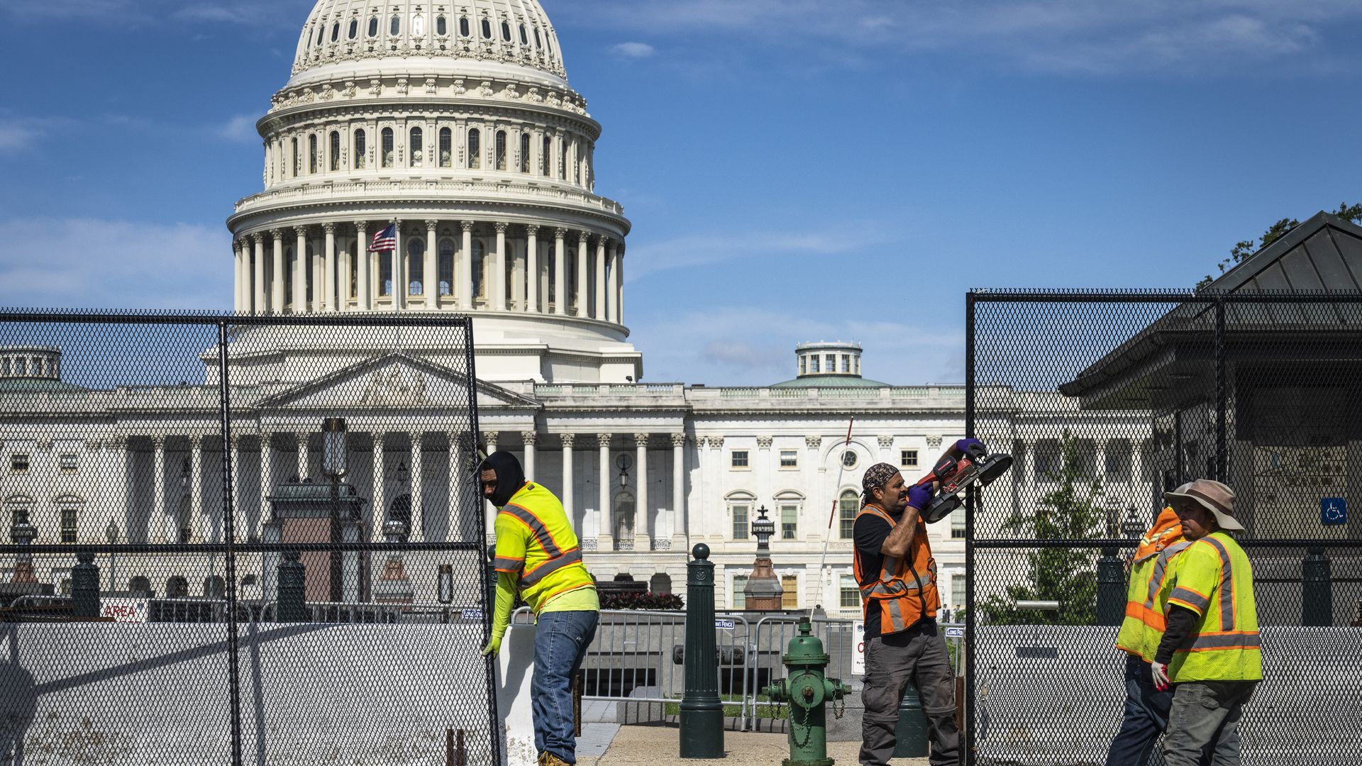 Workers remove security fencing around the U.S. Capitol six months after the riots of Jan. 6, 2020.