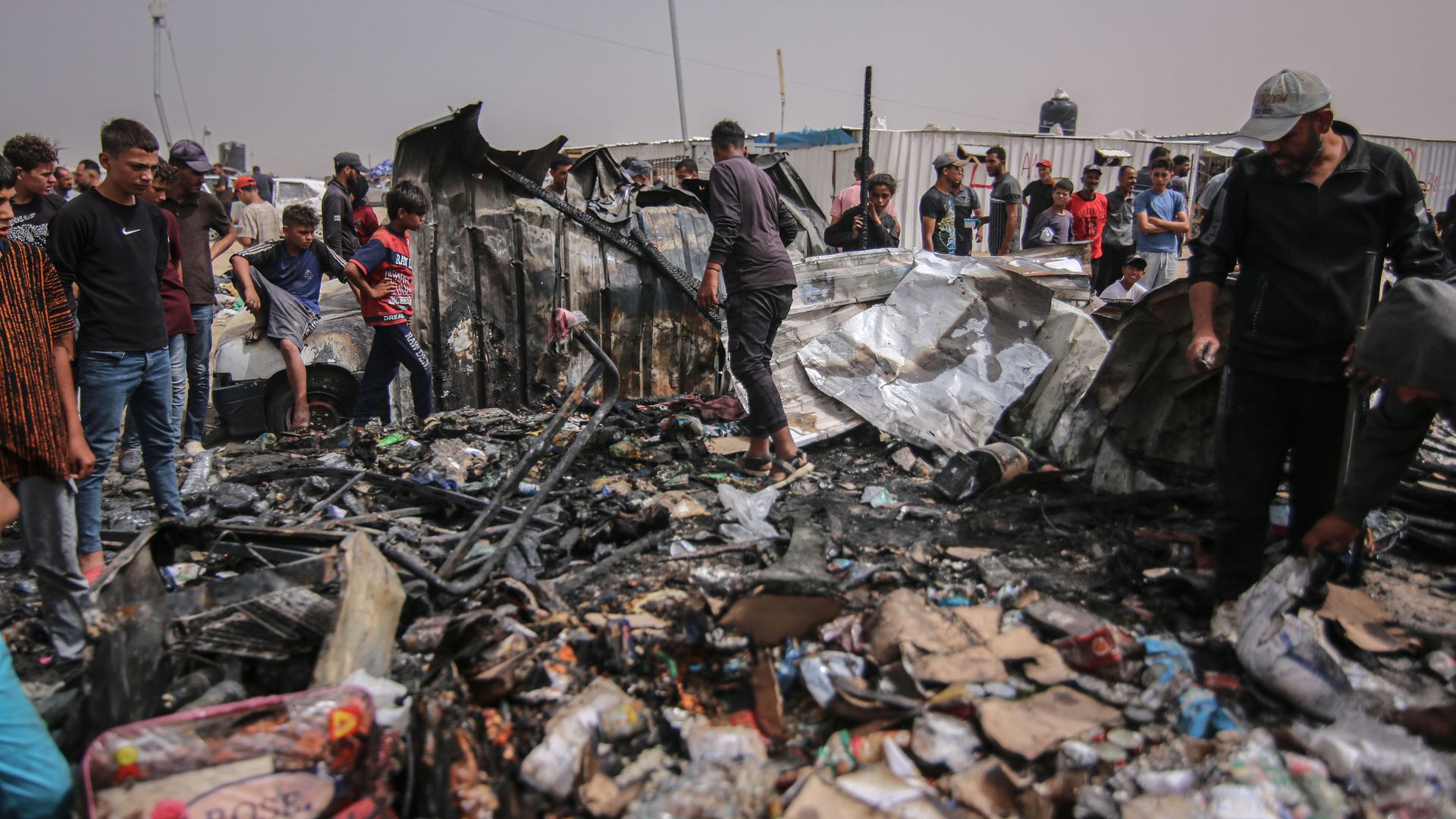 Palestinians inspect damage at the site of an Israeli strike