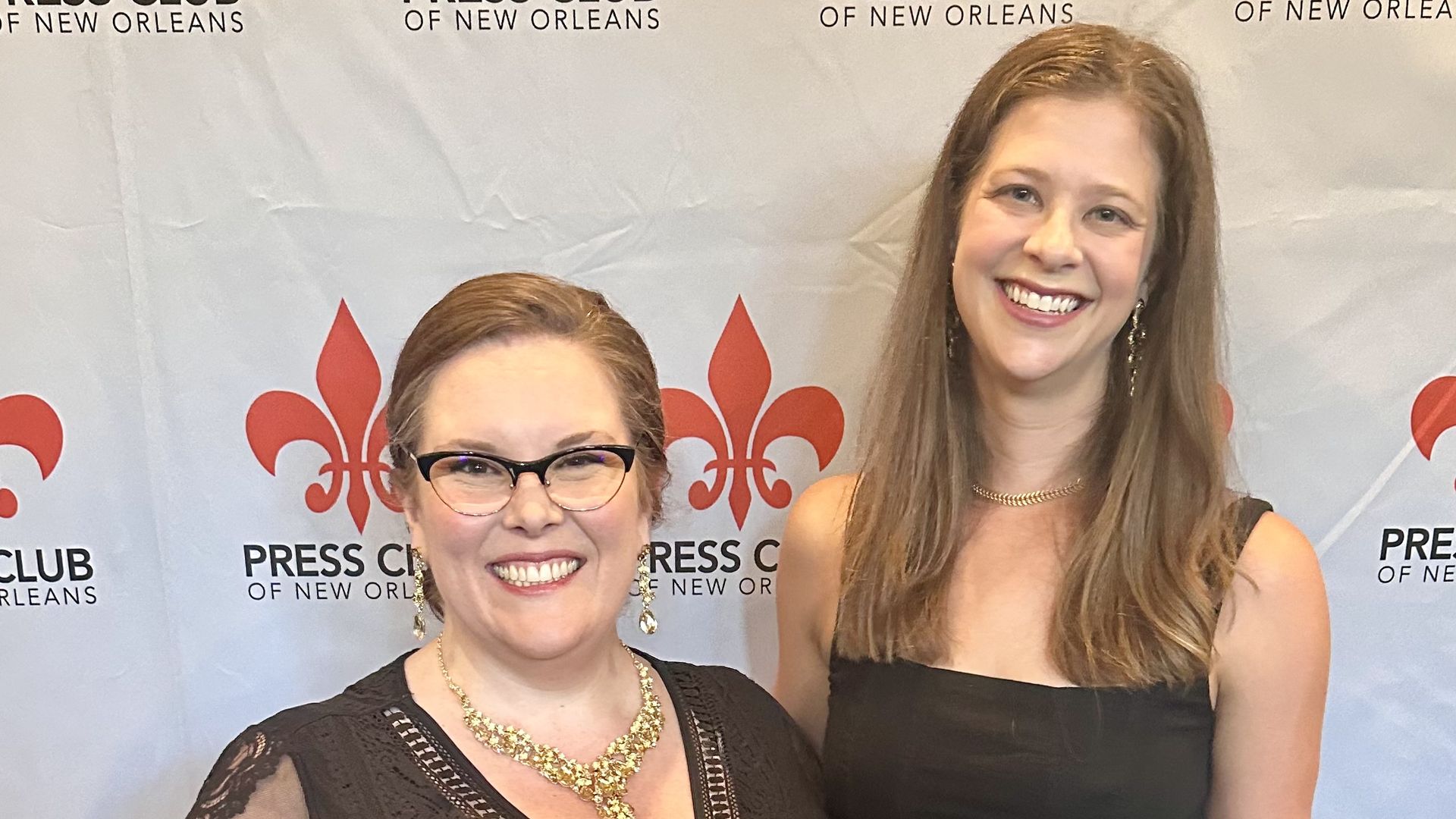 Photo shows Carlie and Chelsea smiling in front of a press club banner